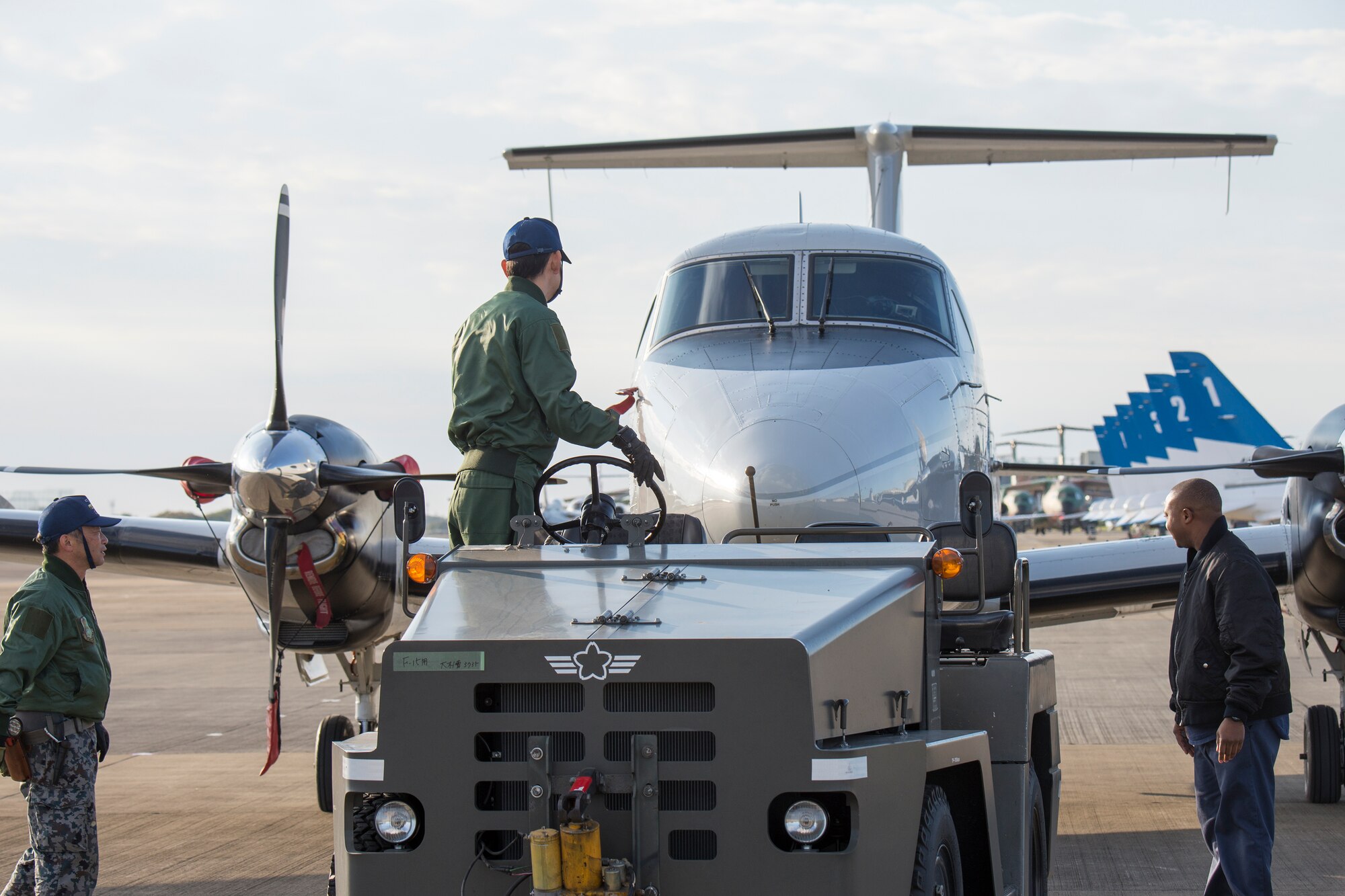 Japan Air Self-Defense Force members push a Yokota C-12 Huron with 459th Airlift Squadron members at Iruma Air Base, Japan, Nov. 3, 2014. The 459 AS brought a UH-1N Huey and a C-12 Huron as static displays during the annual Iruma Air show. (U.S. Air Force photo by Osakabe Yasuo/Released)