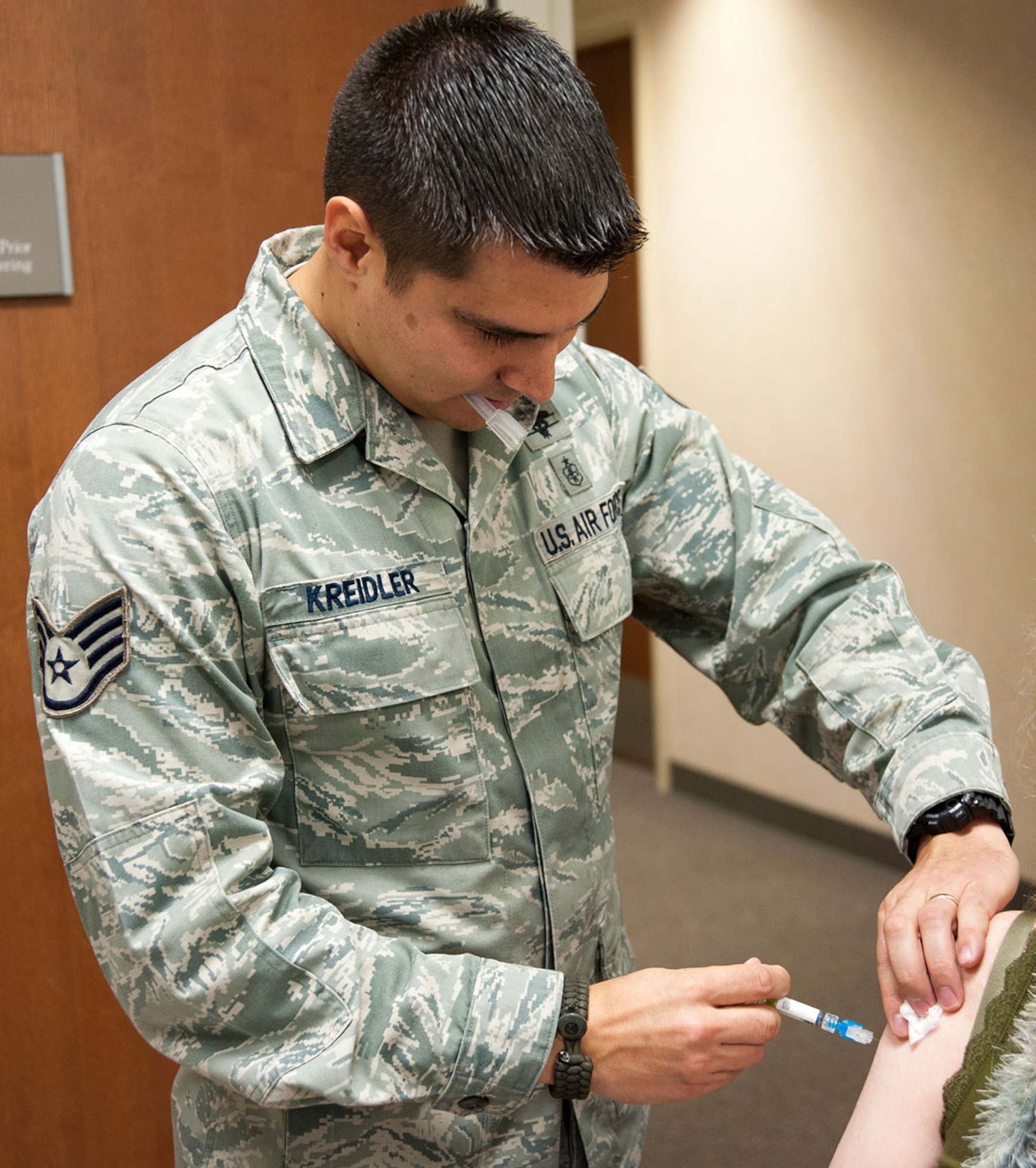 Air Force Staff Sgt. Stephen Kreidler, 673d Medical Group allergy and immunization technician, administers an influenza vaccine to a retiree on Joint Base Elmendorf-Richardson, Alaska, Nov. 5, 2014. The 673d MDG is offering flu vaccines to all military members, their families and retires at the immunization clinic Monday through Friday, from 7:30 a.m. to 4:15 p.m. during the flu season. These vaccines contain egg, so people allergic to egg products need to inform the nurse about their allergy before the shot is administered. (U.S. Air Force photo/Airman 1st Class Tammie Ramsouer)