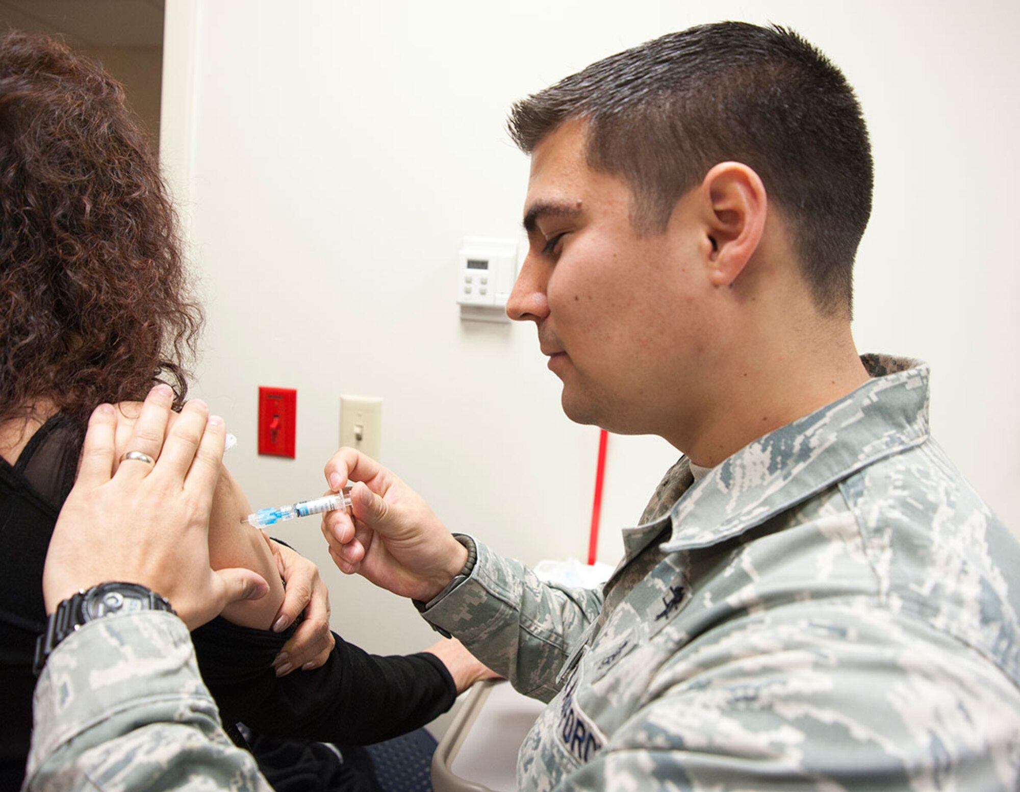 Air Force Staff Sgt. Stephen Kreidler, 673d Medical Group allergy and immunization technician, administers an influenza vaccine to a retiree on Joint Base Elmendorf-Richardson, Alaska, Nov. 5, 2014. The 673d MDG is offering flu vaccines to all military members, their families and retires at the immunization clinic Monday through Friday, from 7:30 a.m. to 4:15 p.m. during the flu season. These vaccines contain egg, so people allergic to egg products need to inform the nurse about their allergy before the shot is administered. (U.S. Air Force photo/Airman 1st Class Tammie Ramsouer)