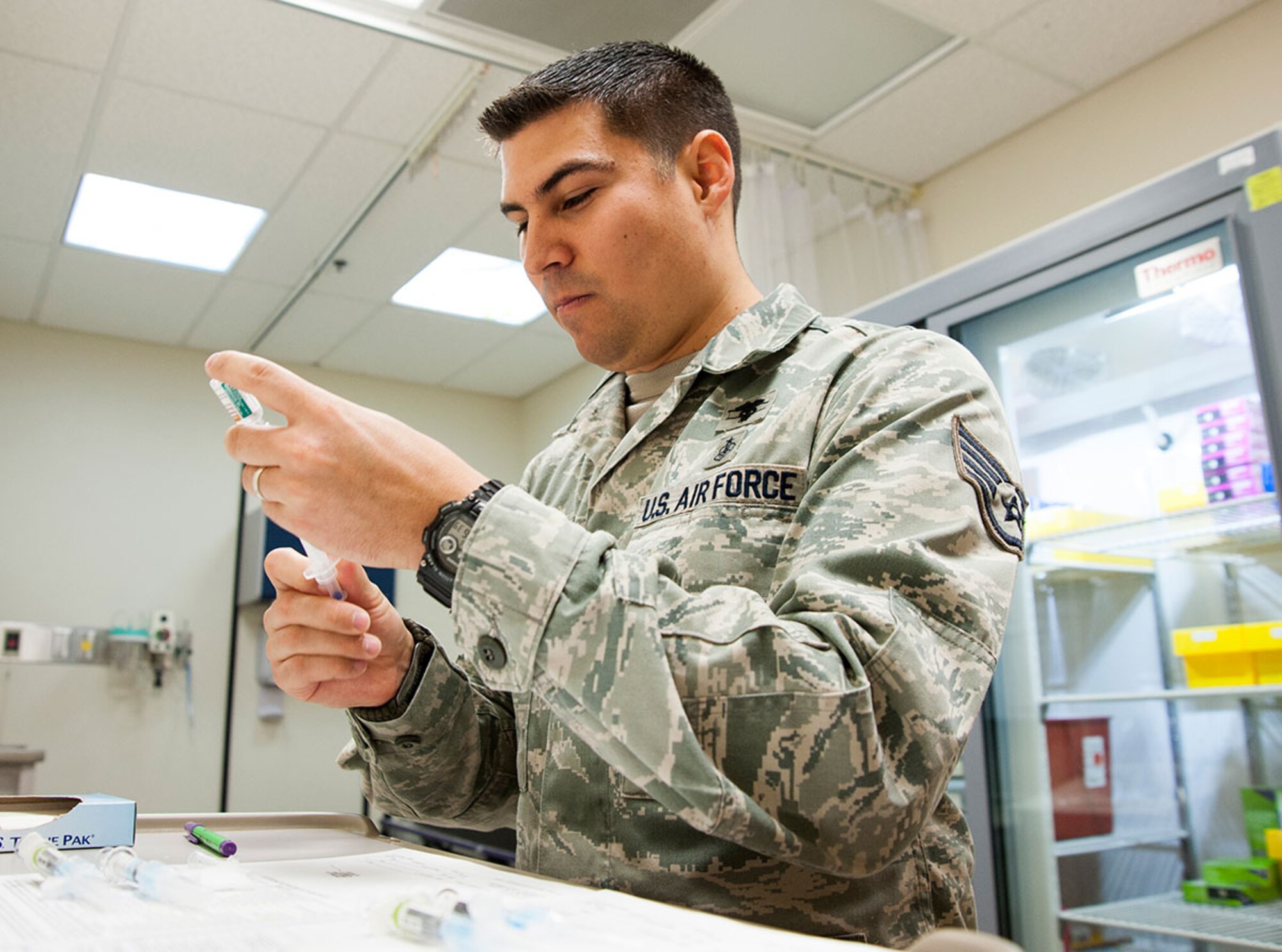 Air Force Staff Sgt. Stephen Kreidler, 673d Medical Group allergy and immunization technician, prepares an influenza vaccine on Joint Base Elmendorf-Richardson, Alaska, Nov. 5, 2014. These vaccines contain egg, so those who are allergic to egg products must inform the nurse administering the vaccine about their allergy before the shot is received. Local pharmacies can administer flu vaccines for those who want one that does not contain egg product. (U.S. Air Force photo/Airman 1st Class Tammie Ramsouer)