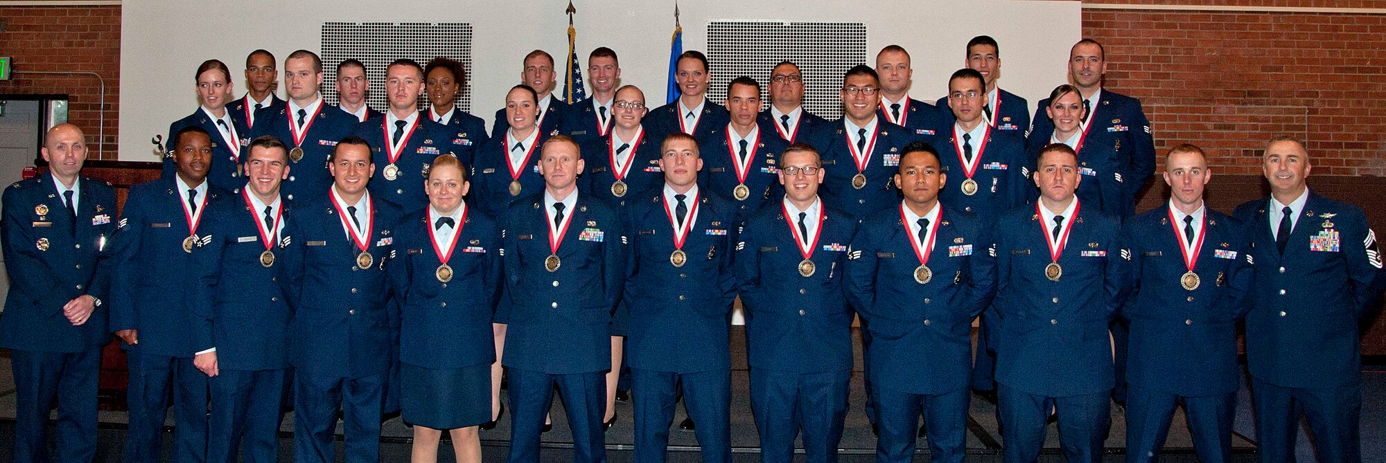 Airman Leadership School Class 15-A poses for a photo with Col. Ronald Allen, 90th Operations Group commander, and Chief Master Sgt. Earnest Jones, 90th Mission Support Group superintendent, in the Fall Hall Community Center, Nov. 5, 2014. Airmen in the class just graduated from ALS in a ceremony held in their honor. Enlisted Airmen must graduate ALS before they can supervise other Airmen. (U.S. Air Force photo by Airman 1st Class Jason Wiese)