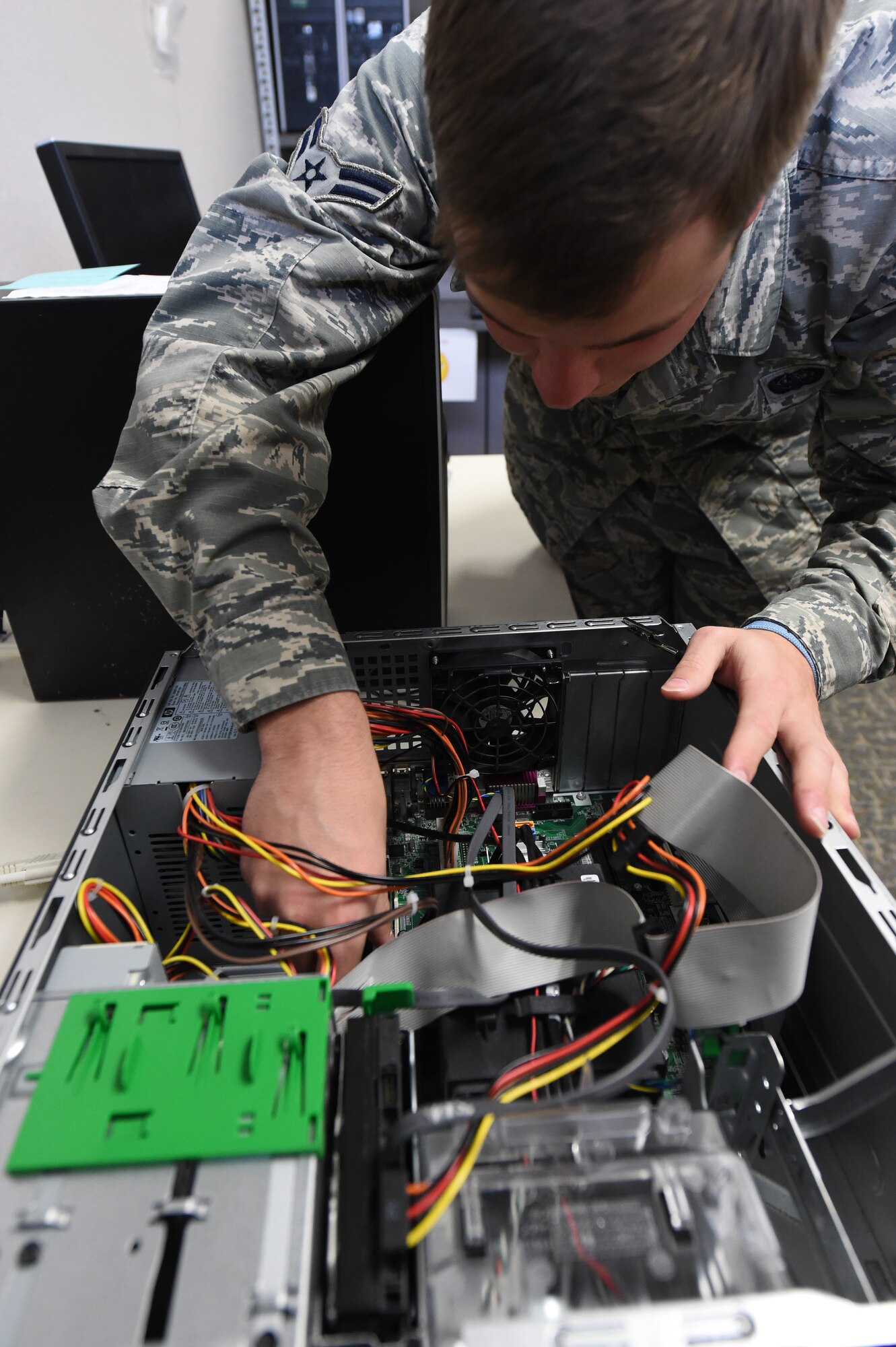 Airman 1st Class Matthew Bruce, 460th Space Communications Squadron client service technician, takes apart a desktop computer Nov. 3, 2014, on Buckley Air Force Base, Colo. The 460th SCS ensures Team Buckley members can continue their mission by fixing computer, phone and printer issues. (U.S. Air Force photo by Airman 1st Class Samantha Saulsbury/Released)