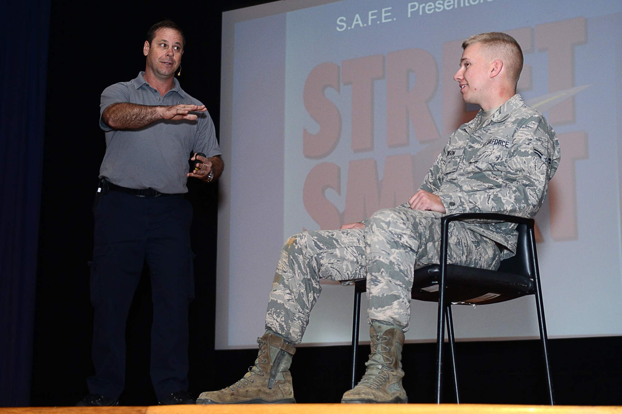 Ralph Jimenez, Miami-Dade County, Fla., Fire-Rescue paramedic, interviews a volunteer onstage during a Street Smart presentation at Langley Air Force Base, Va., Nov. 5, 2014. Jimenez described a hypothetical scenario in which an Airman drinks and drives, accidentally killing himself and two other people. (U.S. Air Force photo by Airman 1st Class Devin Scott Michaels/Released)