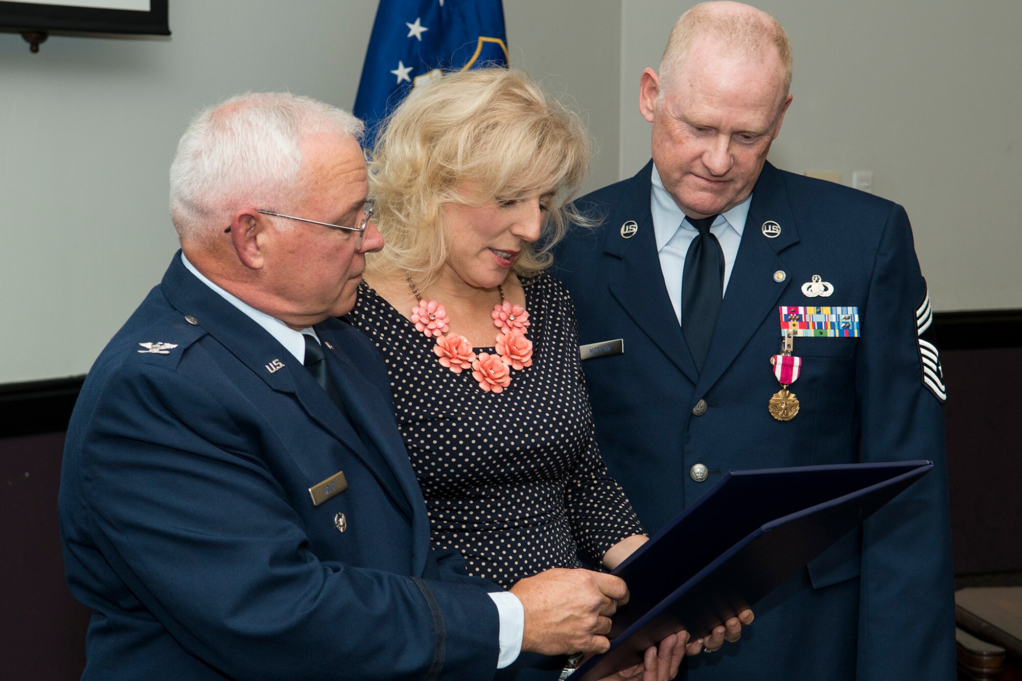 U.S. Air Force Chief Master Sgt. Douglas McClain looks on as his wife, Dianna, is presented the spouse Certificate of Appreciation during his retirement ceremony, Nov. 1, 2014, Barksdale Air Force Base, La. McClain is retiring from the Air Force Reserve after more than 30 years of service. (U.S. Air Force photo by Master Sgt. Greg Steele/Released)