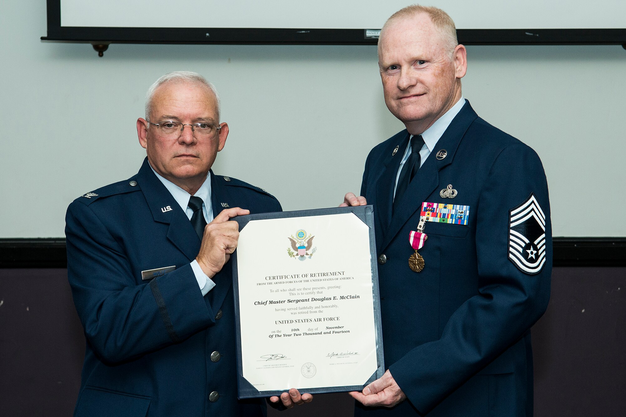 Retired U.S. Air Force Col. Kevin Wolfe, former 307th Mission Support Group commander, presents the Certificate of Retirement to Chief Master Sgt. Douglas McClain during a ceremony on Nov. 1, 2014, Barksdale Air Force Base, La. McClain is retiring from the Air Force Reserve after more than 30 years of service. (U.S. Air Force photo by Master Sgt. Greg Steele/Released)