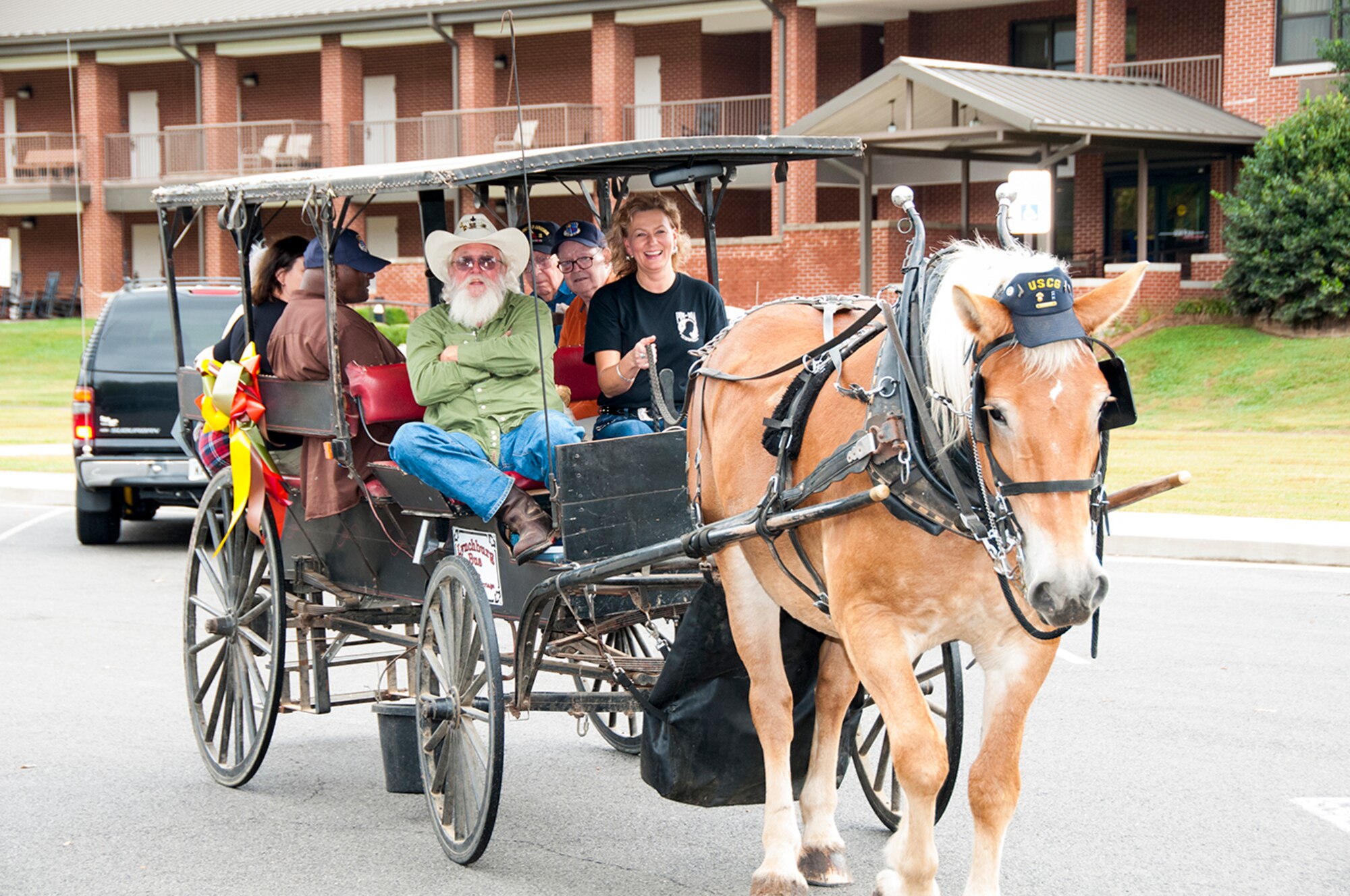 Woodye Bedford (green shirt), from Lynchburg and the owner of the carriage, and AEDC volunteer Denise Counts at the reigns, conduct rides around Arnold Village for the veterans at the AEDC VA Picnic on Oct. 3. (Photo by Rick Goodfriend)
