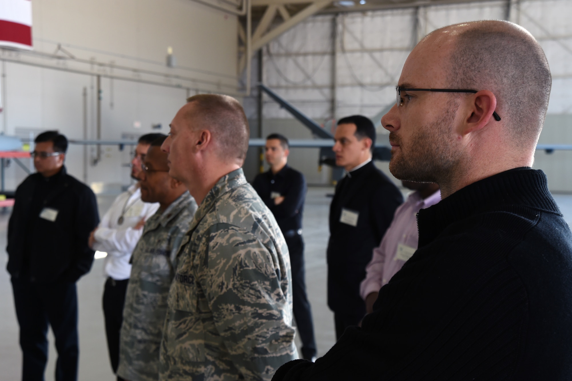 Roman Catholic Chaplain recruits listen to Airmen talk about maintenance on the MQ-1 Predator and MQ-9 Reaper during a “Come Be With Us” chaplain recruiting tour at Creech Air Force Base, Oct. 28, 2014. The tour brings active duty chaplains and civilian priests to Nellis and Creech Air Force Bases to help recruit new chaplains and provides them the opportunity to see different environments in which they might work in. (U.S. Air Force photo by Tech. Sgt. Shad Eidson/Released)