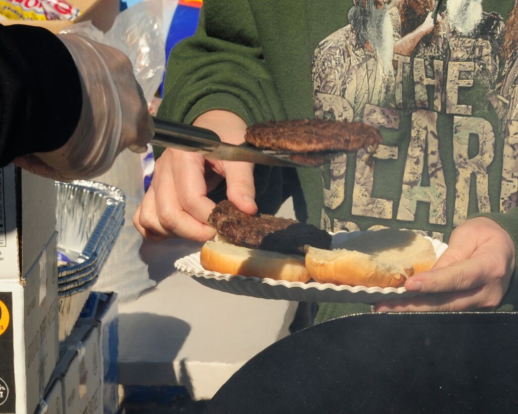 A Tyndall Airman serves a retiree a free burger Nov. 1 at the Base Exchange. Burgers and hotdogs were given to retirees by Tyndall's Top 3 as part of Retiree Appreciation Day. (U.S. Air Force photo by Airman 1st Class Solomon Cook)
