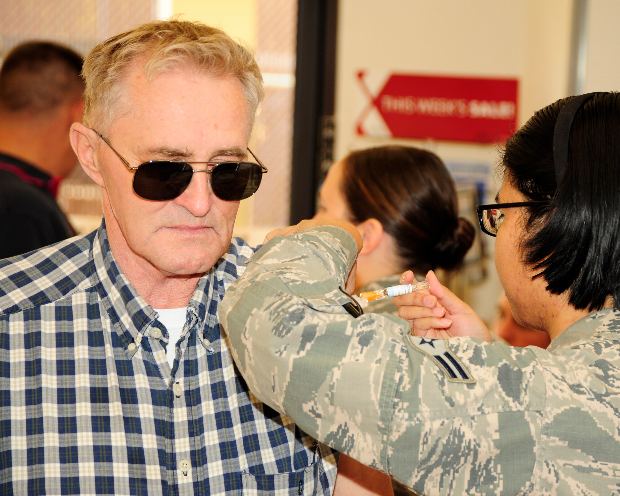 A Tyndall 325th Medical Group Airmen administers a flu shot Nov. 1 to a retiree at the Base Exchange. The flu shot was a station available to retirees for Retiree Appreciation Day. (U.S. Air Force Photo by Airman 1st Class Solomon Cook)