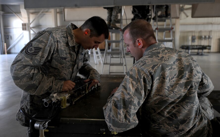 U.S. Air Force Tech. Sgt Robert Cosme, (left), shows 2nd Lt. Zachary Deats, both assigned to the 7th Aircraft Maintenance Squadron, the inner workings of a 14” ejector rack visual aid Oct. 27, 2014, at Dyess Air Force Base, Texas.  Deats and three other officers were selected for a three day weapons load crew training course in order to give them a better understanding of what their Airmen are responsible for on a daily basis. (U.S. Air Force photo by Airman 1st Class Alexander Guerrero/Released) 