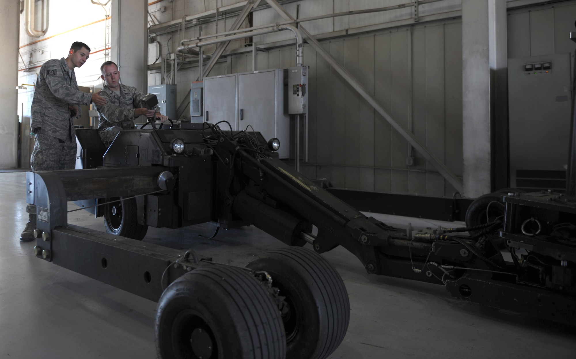 U.S. Air Force Tech. Sgt Robert Cosme, (left), explains to 2nd Lt. Zachary Deats, both assigned to the 7th Aircraft Maintenance Squadron, how to operate a MHU-83 bomb lift truck Oct. 27, 2014, at Dyess Air Force Base, Texas. Deats and three other lieutenants where given the opportunity to undergo weapon load crew training to gain a better understanding of what their Airmen do on a daily basis. (U.S. Air Force photo by Airman 1st Class Alexander Guerrero/Released)