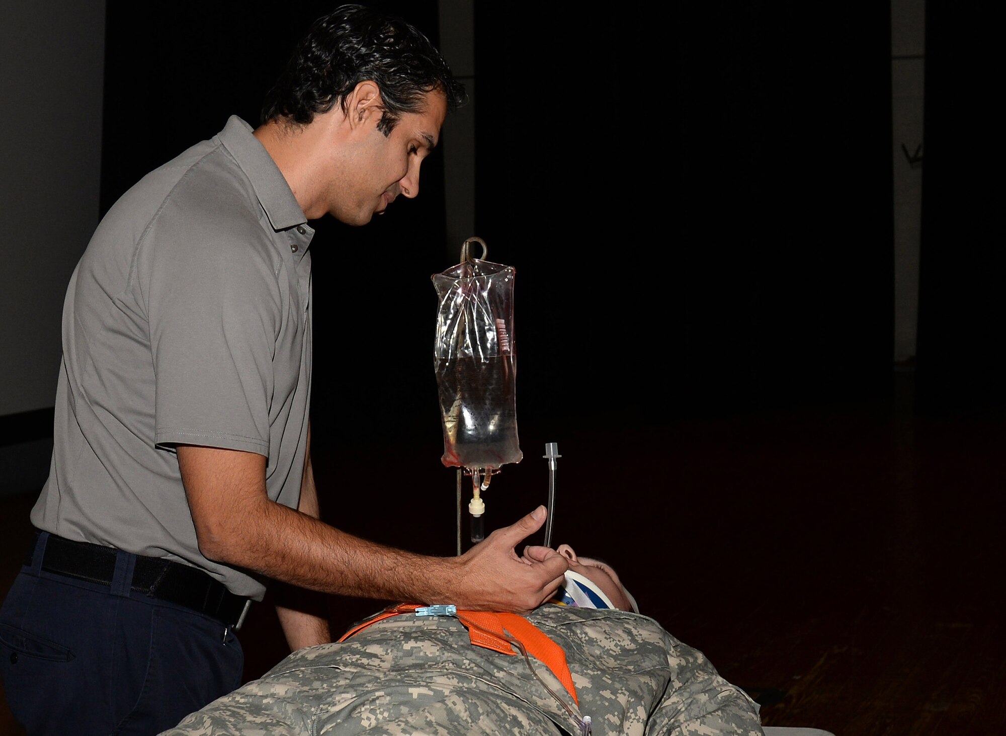 Oscar Duran, Miami-Dade County, Fla., Fire-Rescue paramedic, speaks with a Soldier portraying a vehicle accident victim during the Stay Alive From Education Street Smart Program at Fort Eustis, Va., Nov. 4, 2014. The presentation included graphic photos of vehicle accident victims and descriptive explanations of the steps paramedics and doctors may need to take to save lives of accident victims. (U.S. Air Force photo by Staff Sgt. Teresa J. Cleveland/Released)