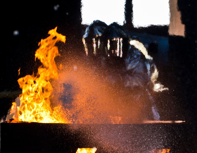 Firefighters from the 919th Special Operations Wing fire the hose at the center of the fire during a training exercise at Eglin Air Force Base, Fla., Oct. 31.  The reserve firefighters from Duke Field used Eglin’s aircraft fire pit to meet their annual training requirements.  (U.S. Air Force photo/Tech. Sgt. Sam King)