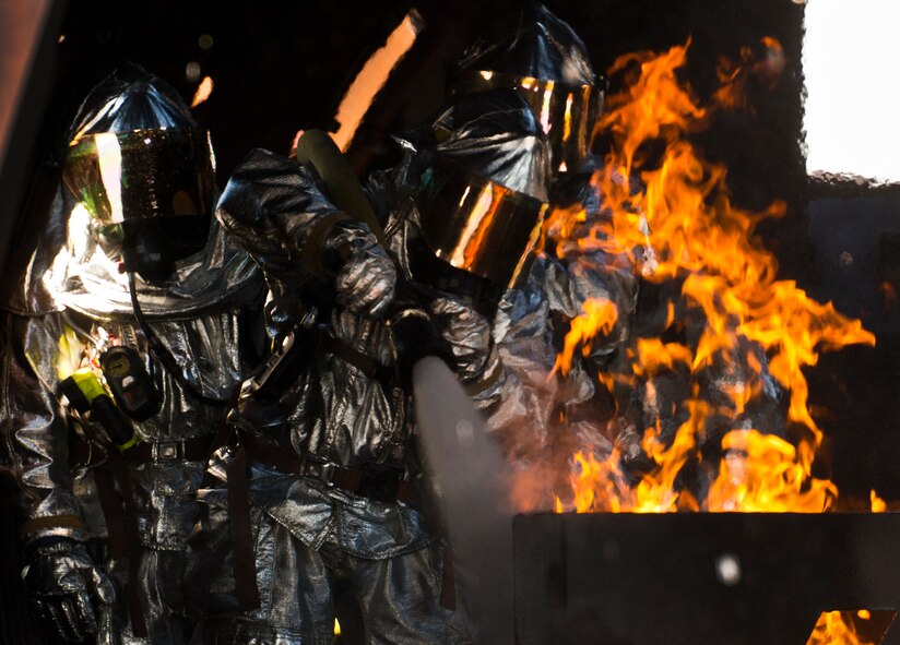 Firefighters from the 919th Special Operations Wing fire the hose at the fire during a training exercise at Eglin Air Force Base, Fla., Oct. 31.  The reserve firefighters from Duke Field used Eglin’s aircraft fire pit to meet their annual training requirements.  (U.S. Air Force photo/Tech. Sgt. Sam King)
