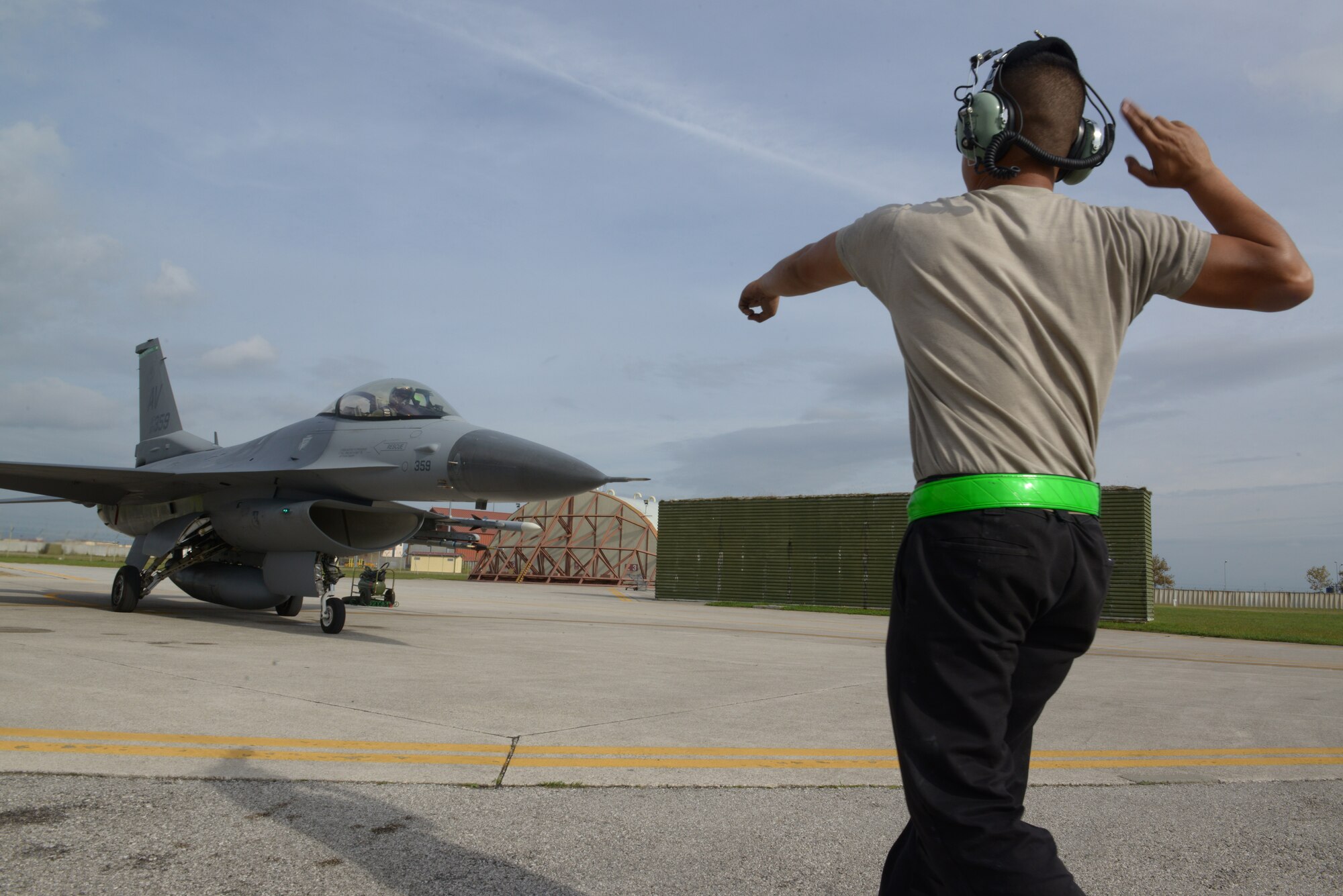 A 31st Aircraft Maintenance Squadron crew chief, signals to Capt. Matthew Alexander, 555th Fighter Squadron pilot, to start his engine and taxi, Oct. 15, 2014, at Aviano Air Base, Italy. The maintainer and pilot both conduct thorough, hands-on safety assessments of the jet before takeoff. (U.S. Air Force photo/Airman 1st Class Ryan Conroy)