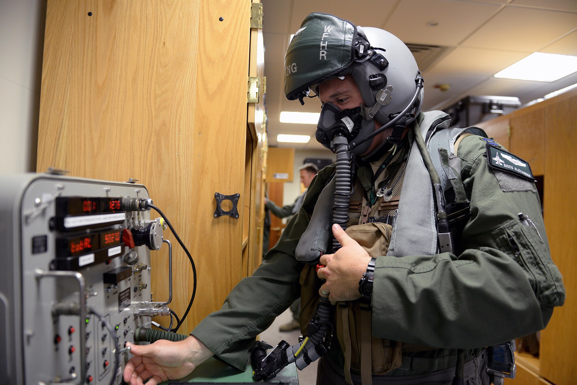 Capt. Matthew Alexander, 555th Fighter Squadron pilot, tests the seal on his lightweight HGU-55/P Combat Edge pilot helmet, Oct. 15, 2014, at Aviano Air Base, Italy. Pilots must wear specialized equipment such as an anti-gravity suit, oxygen equipment, helmets, parachutes and survival gear when flying an F-16 Fighting Falcon. (U.S. Air Force photo/Airman 1st Class Ryan Conroy) 