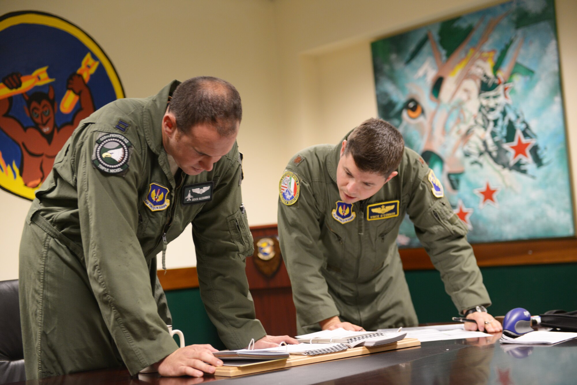 Capt. Matthew Alexander, 555th Fighter Squadron pilot, and Maj. Vincent O’Connor, 31st Fighter Wing commander’s action group, discuss a mission plan before their flight, Oct. 15, 2014, at Aviano Air Base, Italy. Before a flight, pilots go through a pre-flight mission brief to plan for simulated scenarios. (U.S. Air Force photo/Airman 1st Class Ryan Conroy) 