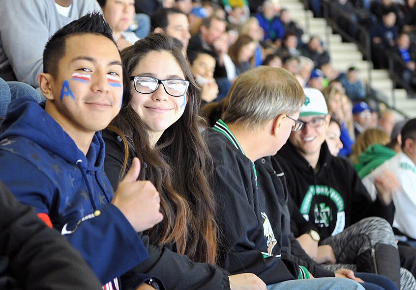 Senior Airman Xavier Navarro, 319th Air Base Wing Public Affairs photojournalist journeyman, and Senior Airman Kimberly Palacios, 319th Comptroller Squadron customer service technician, enjoy the Air Force Academy vs University of North Dakota Hockey Hall of Fame game Nov. 1, 2014, at the Ralph Engelstad Arena in Grand Forks, N.D. The two teams have not faced off against each other on the ice in two years before this game. This event gave 1,000 service members a chance to watch the game at discounted ticket prices. (U.S. Air Force photo/Airman 1st Class Bonnie Grantham)