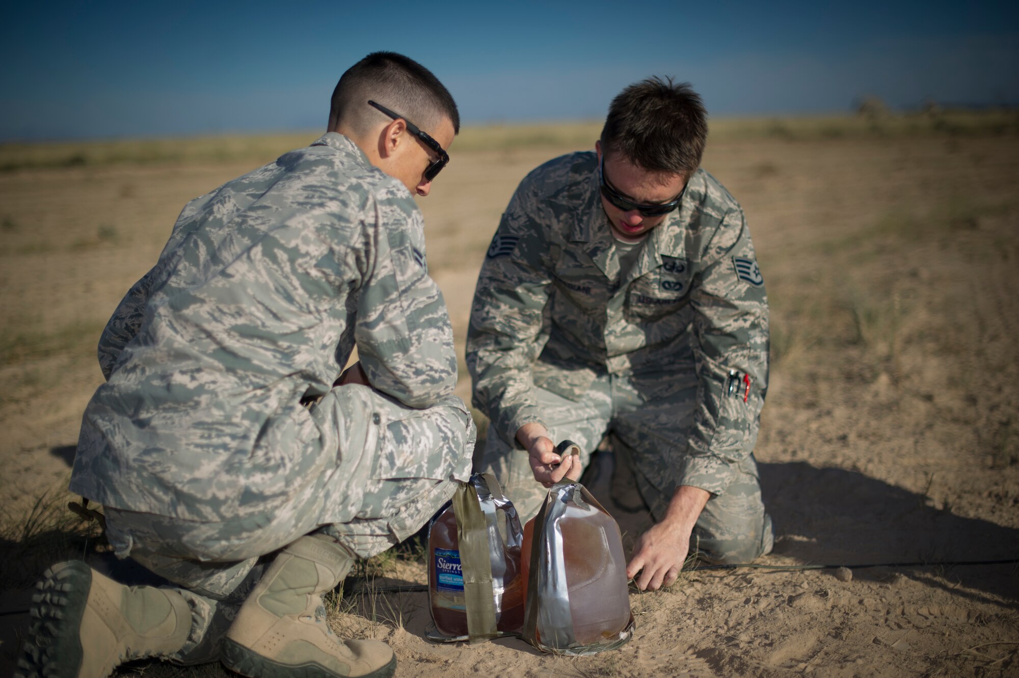 Staff Sgt. Cody Frediani and Airman 1st Class Kevin Oseguera, 49th Civil Engineer Squadron Explosive Ordnance Disposal technicians, make final preparations to an explosive charge at Holloman Air Force Base, N.M., Oct. 28. EOD commemorated the opening of a new demolition range at Holloman by doing an inaugural blast, which consisted of 50 pounds of explosives. Many EOD technicians gathered to help set up the charges and watch the inaugural blast take place. (U.S. Air Force photo by Airman 1st Class Aaron Montoya / Released)