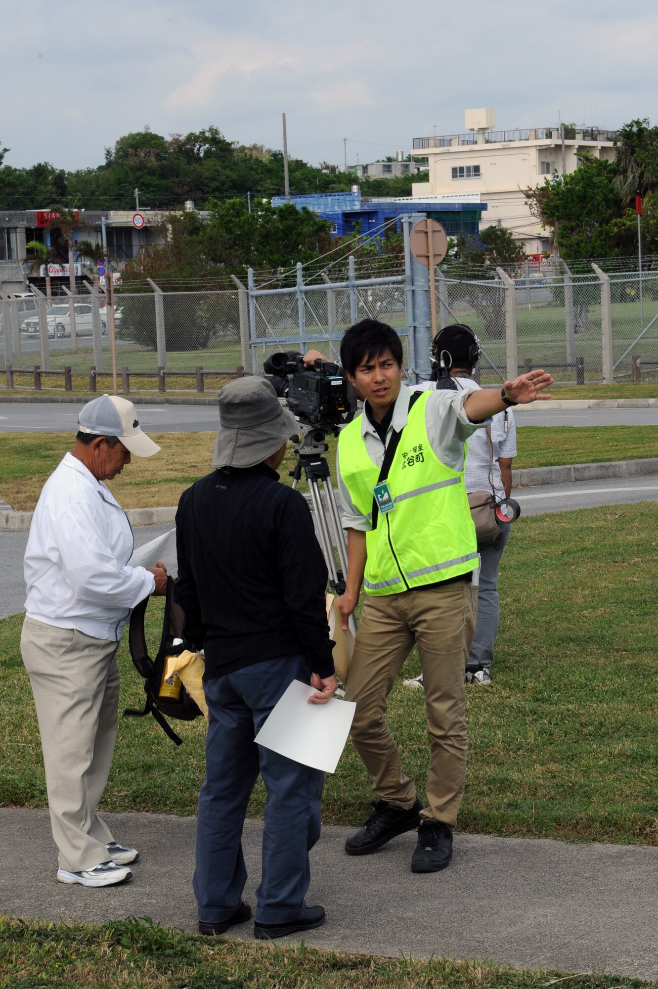 Shun Taira, Chatan Town representative, points exercise participants in the right direction on Kadena Air Base, Japan, Nov. 5, 2014. Residents of Chatan Town participated in the first-ever bilateral exercise simulating the evacuation of local Okinawans from low elevation areas near the Sunabe seawall to higher ground on-base in the event of a natural disaster such as a tsunami. (U.S. Air Force photo by Airman 1st Class Zade C. Vadnais/Released)