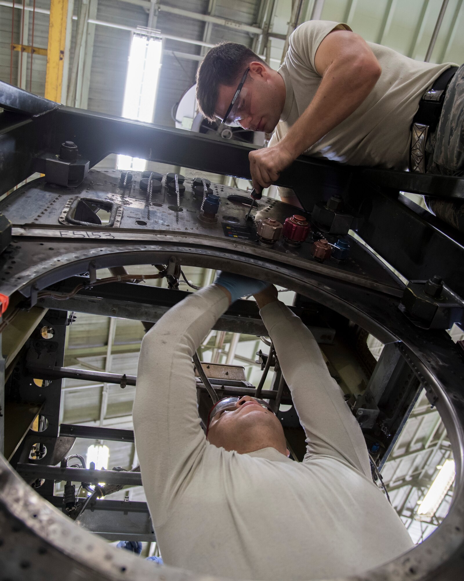 Staff Sgt. Synard Bert, 374th Maintenance Squadron aerospace propulsion flight craftsman (bottom) and Senior Airman Ryan Alexander-Mansker (top), 374 MXS aerospace propulsion journeyman, disassemble parts from the quick engine change kit at Yokota Air Base, Japan, Oct. 29, 2014. After the parts are removed from the kit, it is cleaned, inspected, assembled back together with the serviceable parts and then sent off for painting. (U.S. Air Force photo by Senior Airman Michael Washburn/Released)