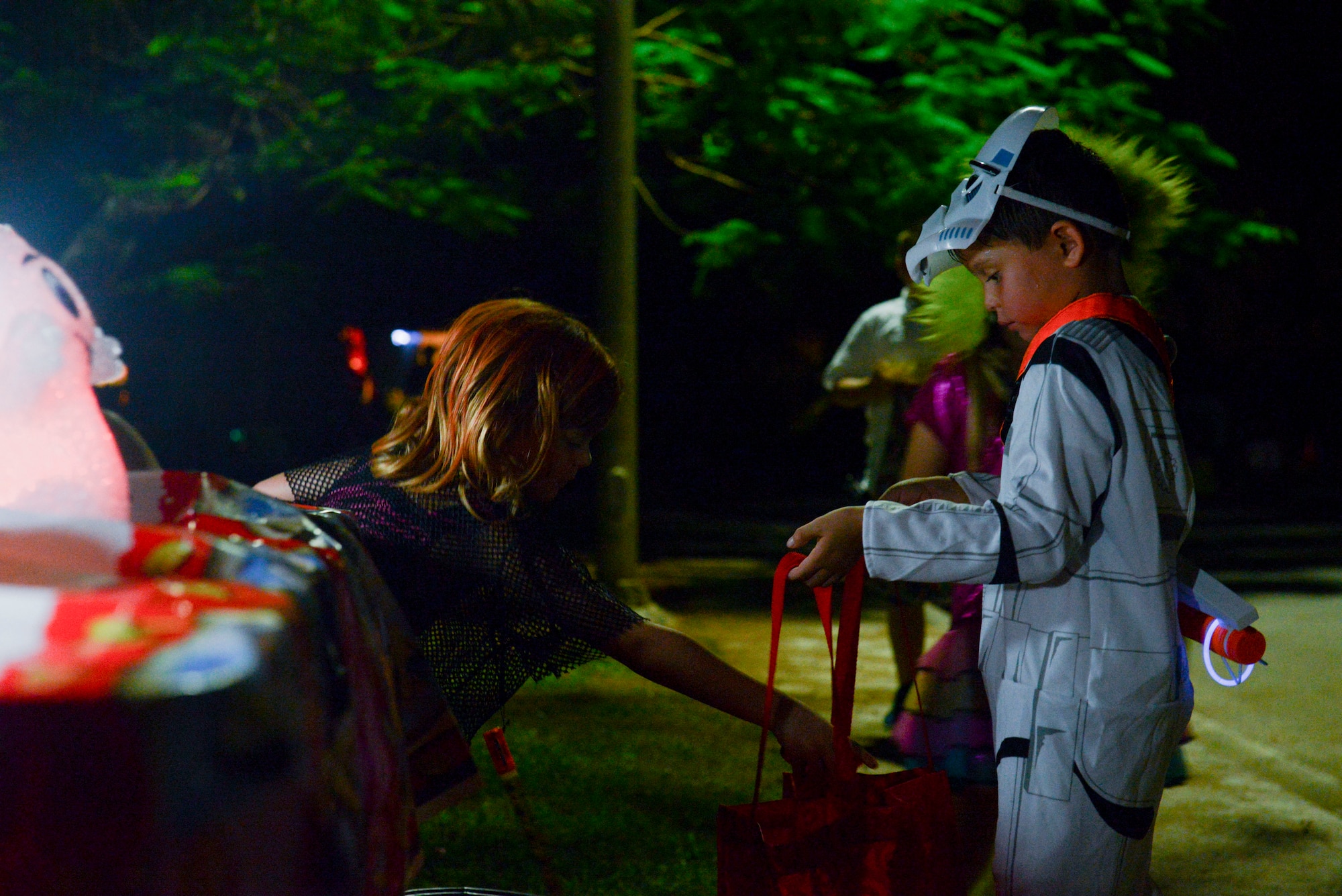 Trick-or-treaters accept candy on Andersen Air Force Base, Guam Oct, 31, 2014. Members of Team Andersen took their children to Rota Drive to trick-or-treat. (U.S. Air Force photo by Senior Airman Adarius Petty /Released)