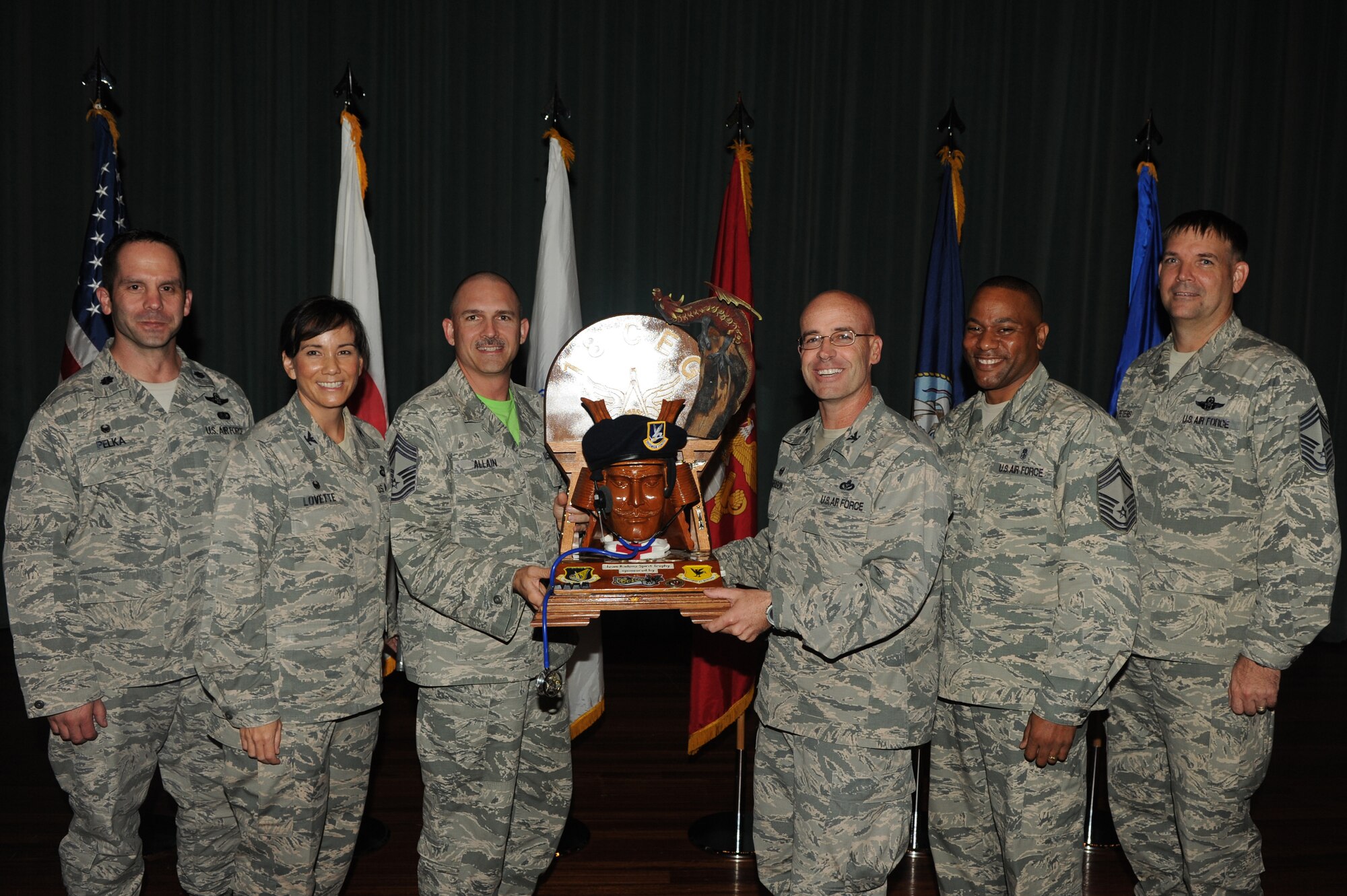 U.S. Air Force Chief Master Sgt. Eric Allain, 18th Civil Engineer Squadron superintendent, and Col. Dwayne Robison, 18th Civil Engineer Group commander, accept the spirit award during Team Kadena's 3rd Quarterly Awards ceremony on Kadena Air Base, Japan, Oct. 31, 2014. This award is given to the Team Kadena unit who showed the most spirit during the ceremony. (U.S. Air Force photo Airman 1st Class Stephen G. Eigel)