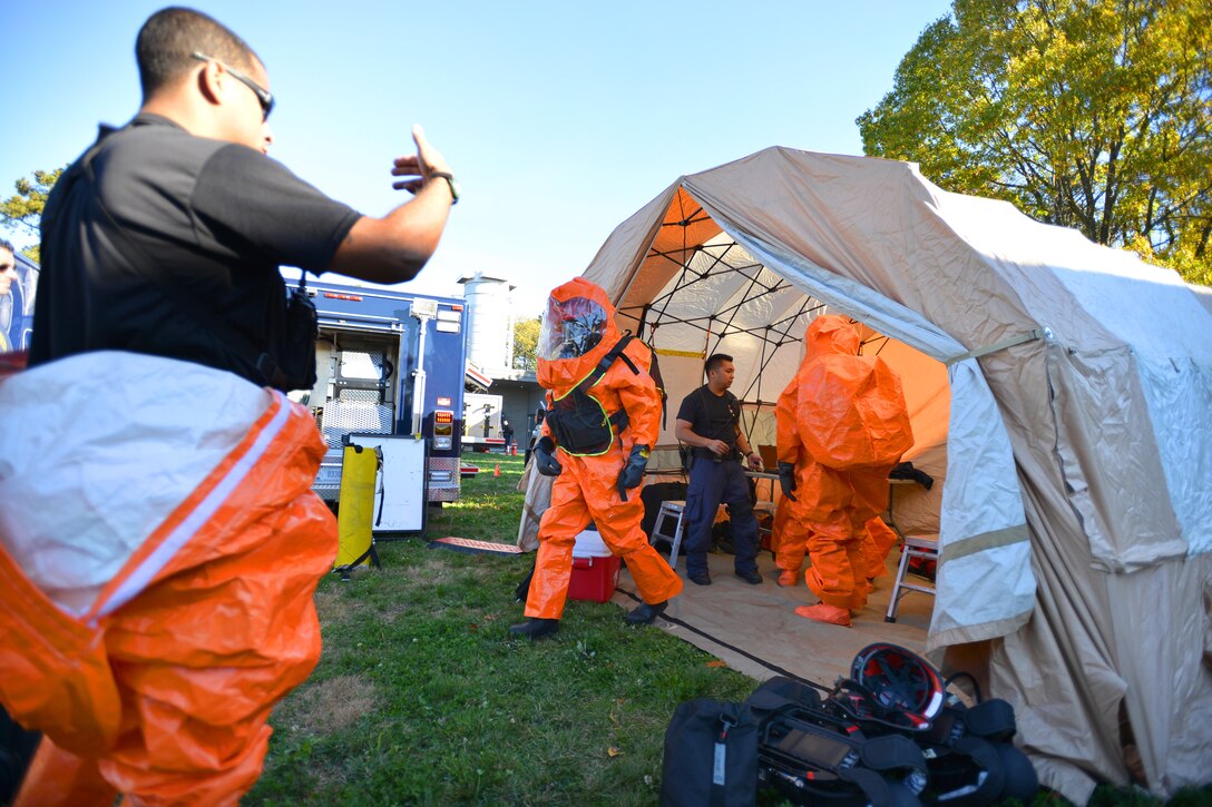A Guardsman, center, exits the decontamination tent during a drill at the Suffolk County Water Authority's New Highway Pump Station, N.Y., Oct. 27, 2014.