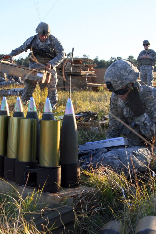 Army Spc. Christopher Espinoza, foreground, awaits a fire mission ...