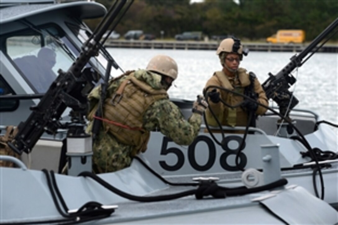 Navy Petty Officer 3rd Class Kayla Lewis, right, casts off the forward mooring line of a 34-foot patrol boat during exercise Bold Alligator 2014 near Marine Corps Air Station New River in Jacksonville, N.C., Nov. 1, 2014. Lewis is a boatswain's mate assigned to Coastal Riverine Squadron 4. 