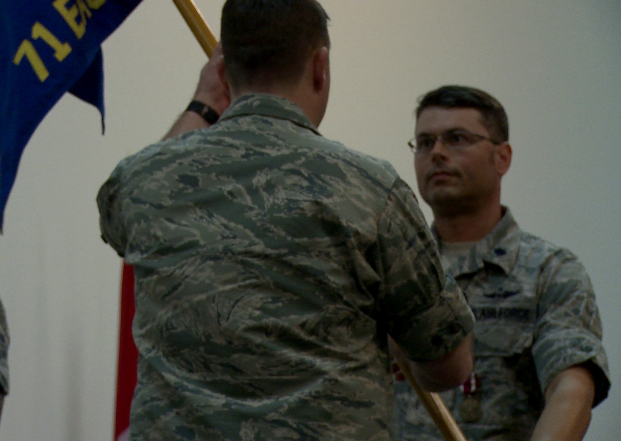 U.S. Air Force Lt. Col. Christopher Wachter, left, 379th Expeditionary Operations Group deputy commander, and Lt. Col. Stuart Williamson, 71st Expeditionary Air Control Squadron commander, hold a guidon during an inactivation ceremony for the 71st EACS Nov. 1, 2014, at Al Udeid Air Base, Qatar. During the ceremony, in accordance with Air Force tradition, the squadron’s guidon was rolled up and cased.