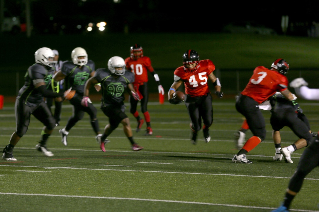 Leo Briggs, Marine Corps Air Station Miramar Falcons’ running back dodges several Headquarters Support Battalion Spartan defenders during a game aboard Marine Corps Base Camp Pendleton, Calif., Nov. 4. The Falcons lost to the Spartan 7-0 in overtime.