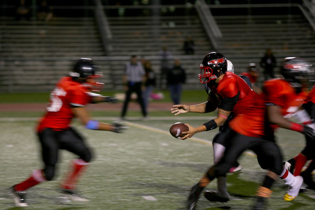 Greg Sargeant, Marine Corps Air Station Miramar Falcons’ quarterback, hands the football off to Leo Briggs, Falcons’ running back during a game against the Headquarters Support Battalion Spartans aboard Marine Corps Base Camp Pendleton, Calif., Nov. 4. The Falcons lost to the Spartans 7-0, ending their chances for the title of “Best in the West.”