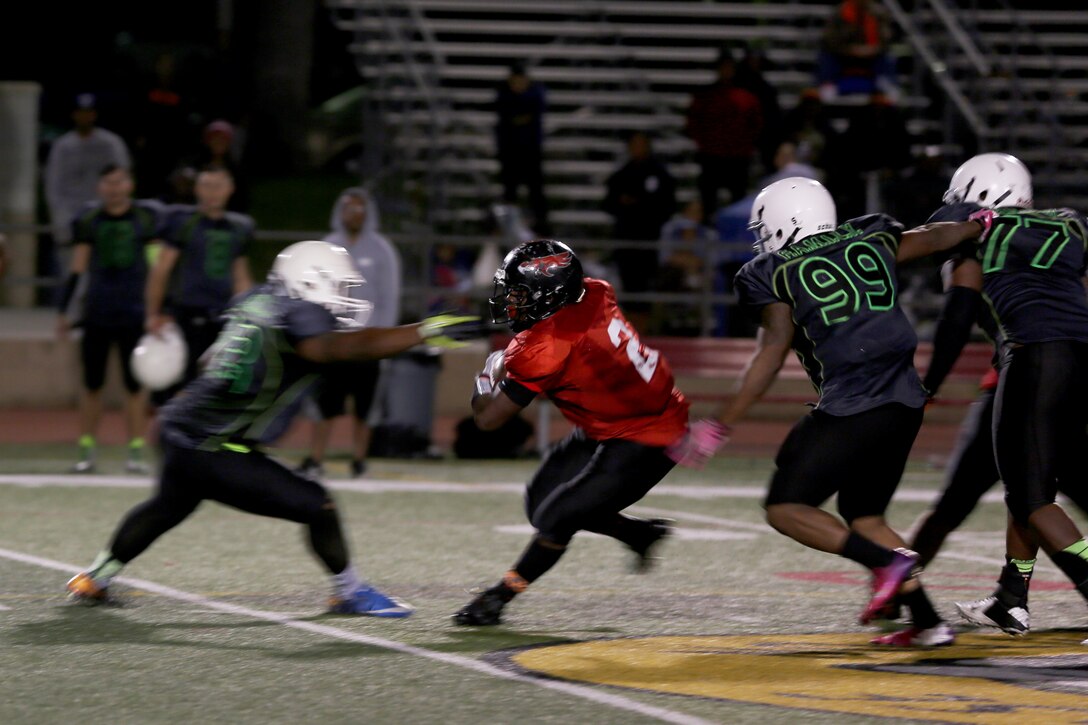 Patrick Williams, Marine Corps Air Station Miramar Falcons’ fullback, dodges a Headquarters Support Battalion Spartan defender during a football game at Paige Fieldhouse aboard Marine Corps Base Camp Pendleton, Calif., Nov. 4. The Falcons lost to the Spartans 7-0 ending their playoff run.