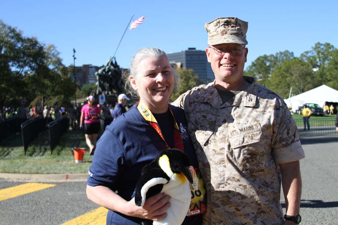 Carol Wilander receives the Penguin Award from Col. David W. Maxwell, commander, Marine Corps Base Quantico, signifying that she was the last official finisher of the 39th Annual Marine Corps Marathon on Oct. 26.