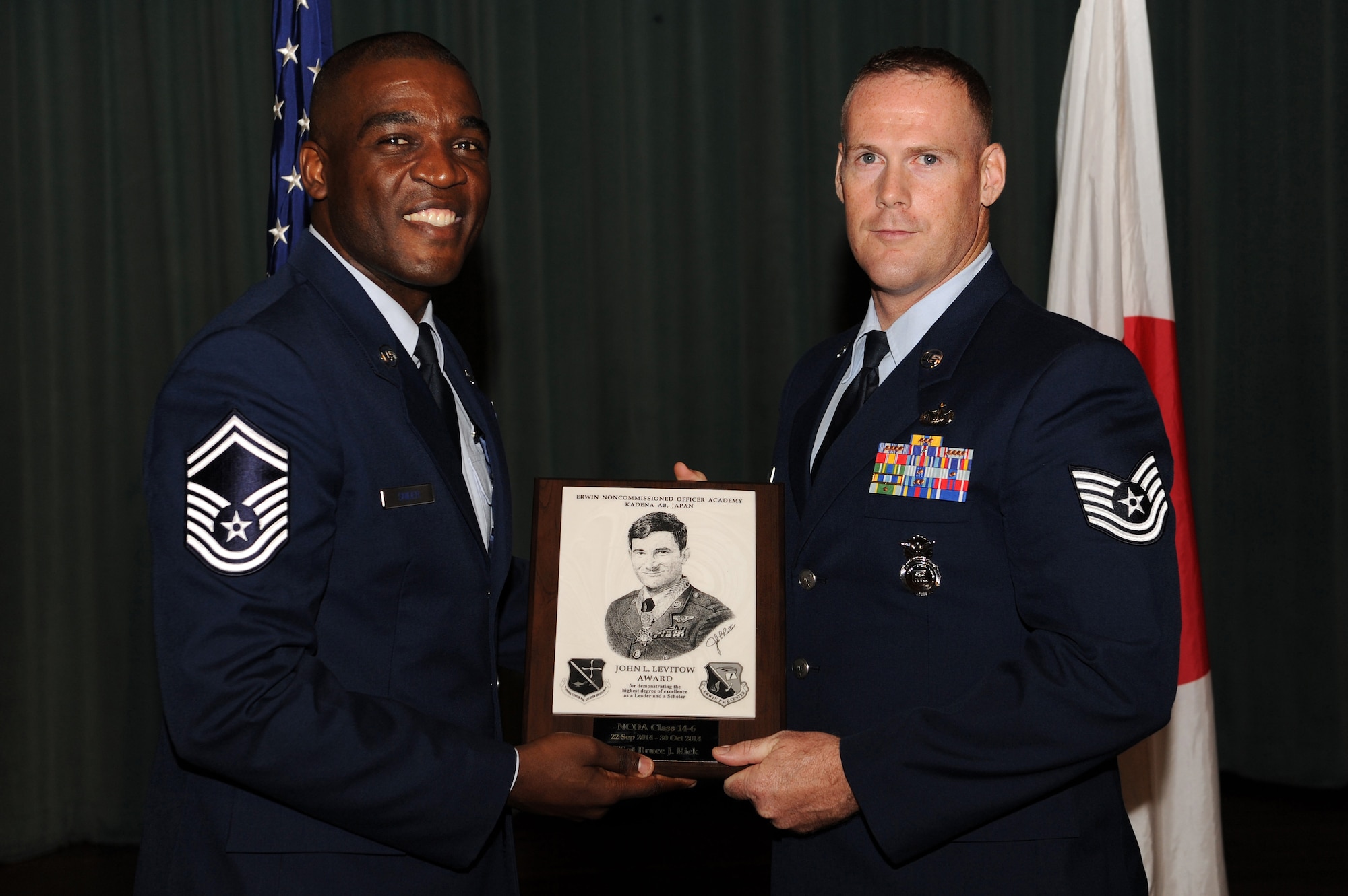 U.S. Air Force Tech. Sgt. Bruce J. Rick, 31st Rescue Squadron, accepts the John L. Levitow Award during the graduation ceremony for NCO Academy Class 14-6 on Kadena Air Base, Japan, Oct. 30, 2014. The John L. Levitow Award is presented to the student who earns the highest average score on evaluations and most embodies the Air Force core values. (U.S. Air Force photo by Airman 1st Class Zade C. Vadnais/Released)