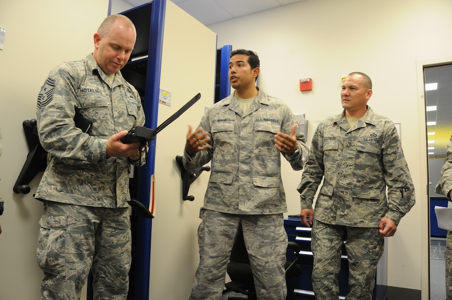 U.S. Air Force Tech. Sgt. Daniel N. Rosas, AFE craftsman for the 15th Operation Support Squadron, and Senior Master Sgt. Kyle I. Marshman, AFE Superintendent of the 154th Operations Support Squadron, Hawaii Air National Guard, describe the capabilities of new radio equipment to Senior Master Sgt. James W. Hotaling, command chief master sgt. of the Air National Guard, during his visit to the 154th Wing at Joint Base Pearl Harbor Hickam on Nov. 5, 2014. Rosas and Marshman are part of a TFI unit that integrates active duty and guard assets. (U.S. Air Force photo by Airman 1st Class Robert Cabuco)