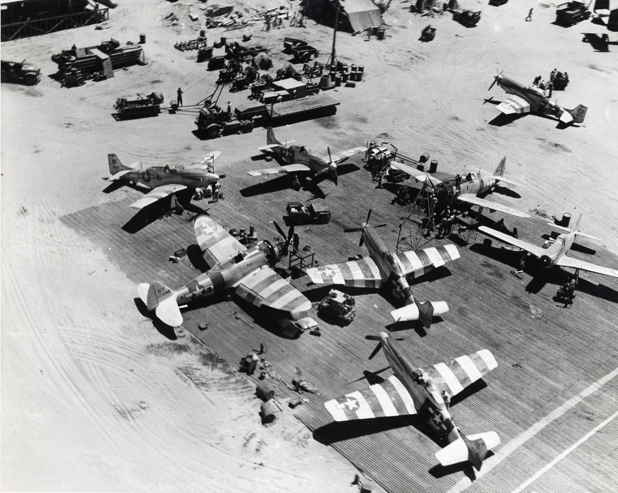 Two P-47 Thunderbolts and six P-51 Mustangs in the maintenance area of the 35th Fighter Group, Lingayen Airfield, Luzon, Philippines, April 1945.  (U.S. Air Force Photo)