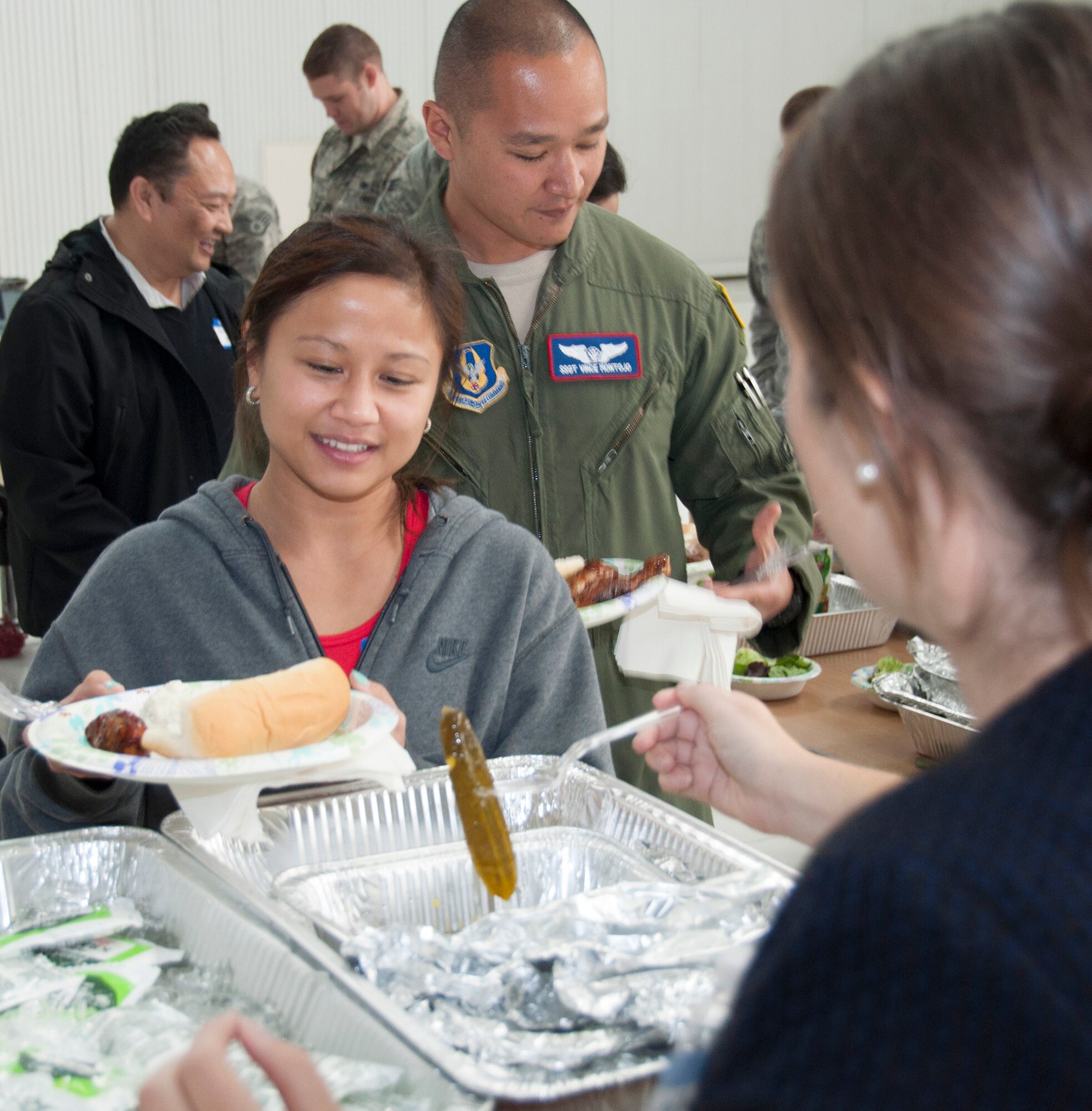 TRAVIS AIR FORCE BASE, Calif. -- Staff Sgt. Vince Montojo and his wife Maya are served a barbecue lunch by Brittney Cipolla as part of the 349th Air Mobility Wing's Focus on the Family event Oct. 25, 2014, at Travis Air Force Base, Calif. The event included an orientation flight for spouses on either the KC-10, C-5, or C-17 aircraft, briefings and informative sessions on the benefits of being an Air Force Reserve spouse and a barbecue lunch to bring together all as part of the "349th Family". Another Focus on the Family event is scheduled to be held during the November 2014 A Flight Unit Training Assembly weekend. Montojo is a boom operator assigned to the 79th Air Refueling Squadron. Cipolla is the wing's Airman and Family Readiness director. (U.S. Air Force photo/2nd Lt. Stephen J. Collier) 