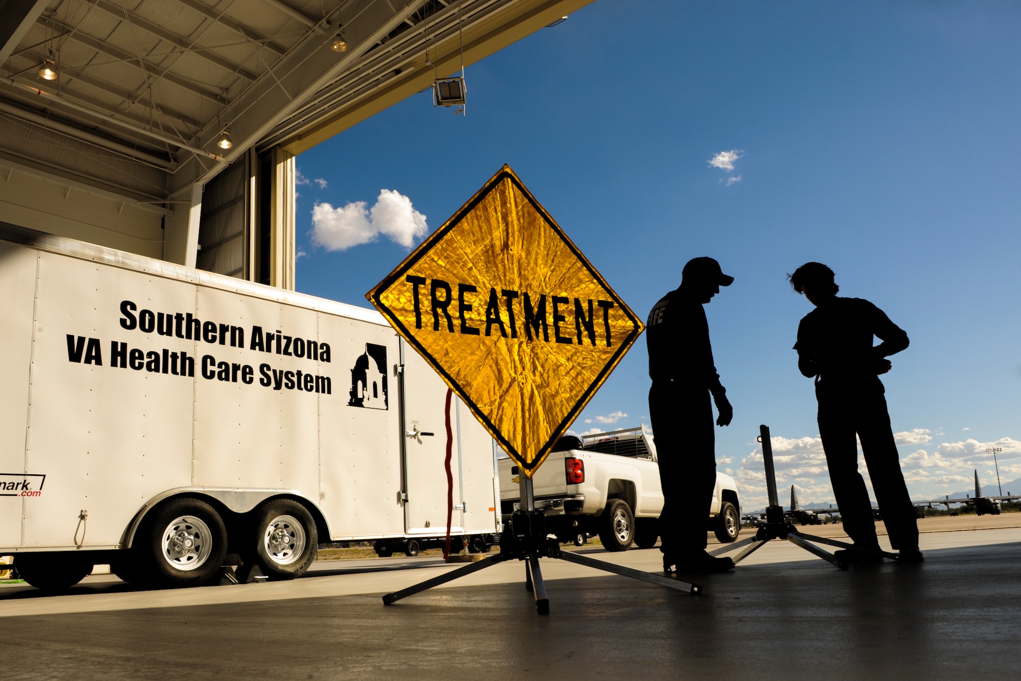 Firefighters from Golder Ranch Fire District and Tucson Airport Authority Fire Department assemble medical care signs a part of a triage area at Davis-Monthan Air Force Base, Ariz., Nov. 4, 2014. The triage area was set up in conjunction with a simulated response to a natural disaster on the Gulf Coast requiring patients to be flown to Ariz., to receive treatment. (U.S. Air Force photo by Airman 1st Class Chris Drzazgowski/Released)