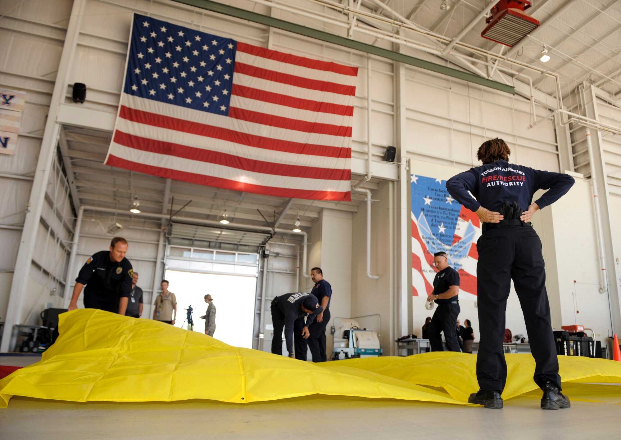 Firefighters from multiple agencies in Tucson, Ariz., construct a triage area in a hangar at Davis-Monthan Air Force Base, Ariz., Nov. 4, 2014. The triage area is part of a simulated response to a natural disaster involving the partnership of D-M, local emergency response agencies and the Southern Arizona Veterans Affairs Health Care System. (U.S. Air Force photo by Airman 1st Class Chris Drzazgowski/Released)