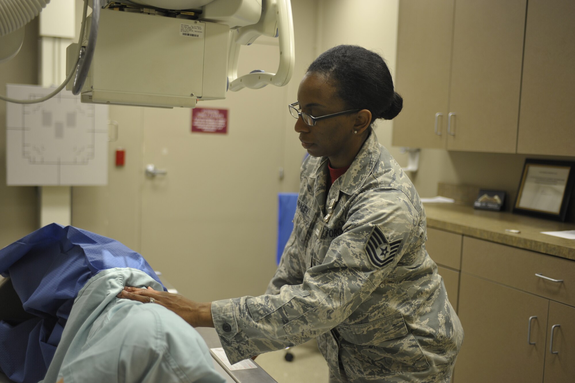 Tech. Sgt. Katina Fraley, 92nd Medical Support Squadron diagnostic imaging NCO in charge, positions a patient in order to be able to take an X-ray of her back Oct. 31, 2014, at Fairchild Air Force Base, Wash. Her leadership selected her as a member of Team Fairchild’s elite, Fairchild’s Finest. (U.S. Air Force photo/Airman 1st Class Taylor Bourgeous)