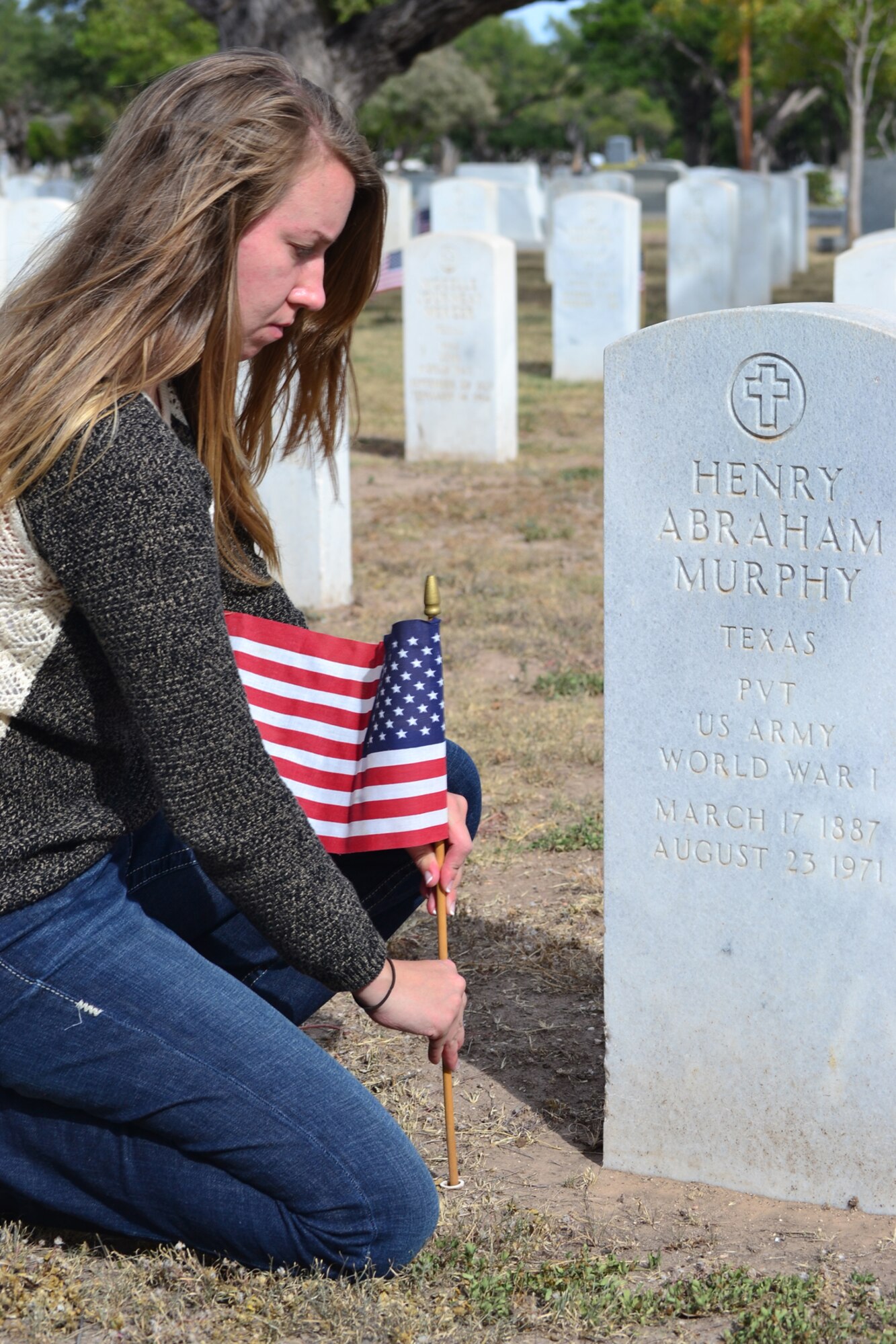 SAN ANGELO, Texas – Airman 1st Class Casey Vaughn, 17th Medical Operations Squadron Mental Health technician, places a U.S. flag at the grave site of Army Pvt. Henry A. Murphy, World War I veteran, at Fairmount Cemetery Nov. 3.  Placing the flags at veterans’ grave stones is an annual event to honor veterans and commemorate the signing of the armistice which ended World War I.  (U.S. Air Force Photo/Lucian Czarnecki)