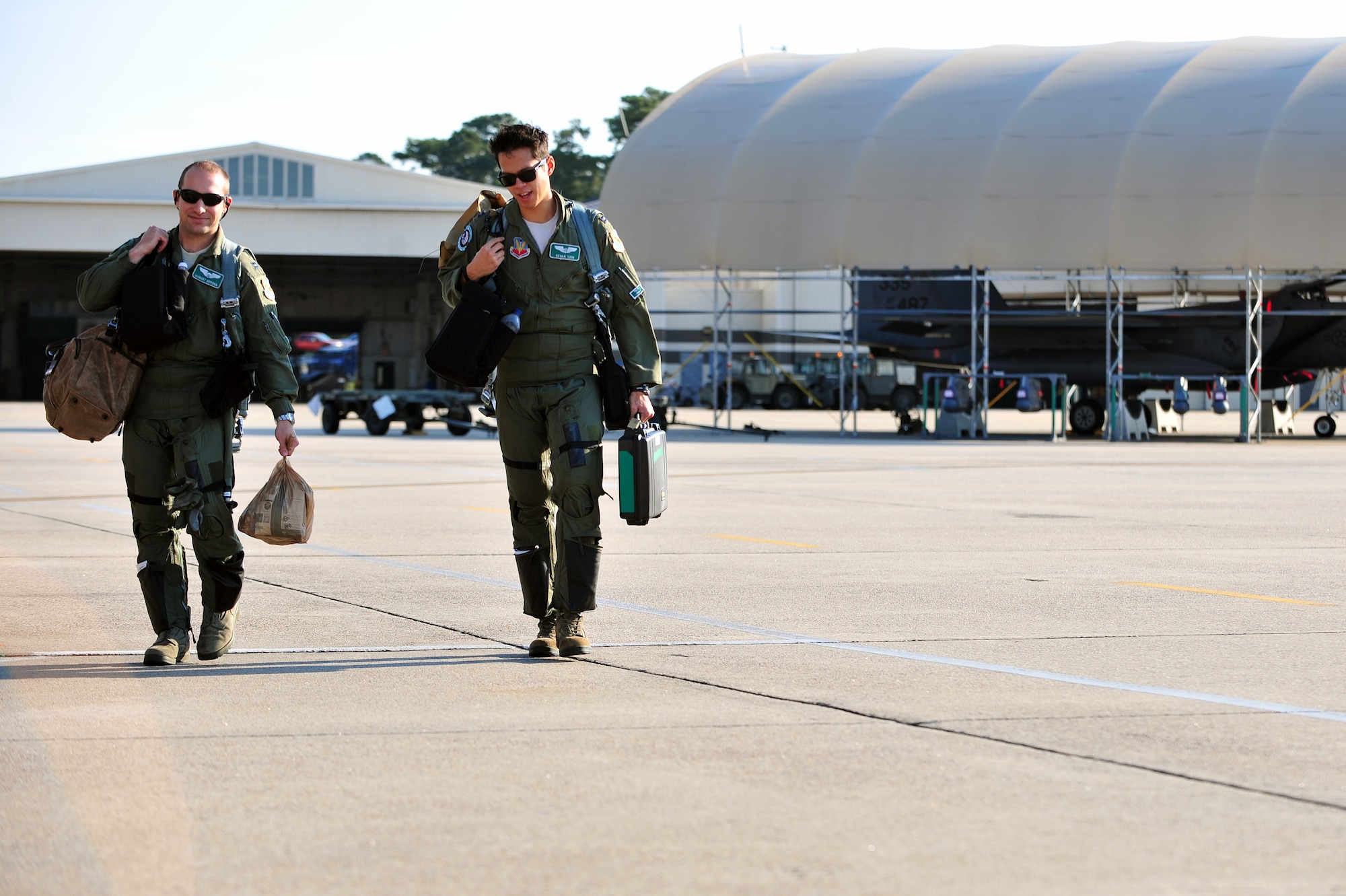 Capt. August Derosa (left) and Capt. Kevan Tjon, both weapons systems officers with the 335th Fighter Squadron, head out to their F-15E Strike Eagles at Seymour Johnson Air Force Base, North Carolina, Oct. 11, 2014, before heading to Nellis Air Force Base, Nevada, in support of the U.S. Air Force Weapons School’s Weapons Instructor Course. Airmen and aircraft assigned to the 4th Fighter Wing out of Seymour Johnson AFB recently returned home from Nellis AFB, where they were tasked with enhancing the F-15E Strike Eagle capability and providing additional air support for the students attending the Weapons School’s Weapons Instructor Course. (U.S. Air Force photo/Senior Airman John Nieves Camacho)