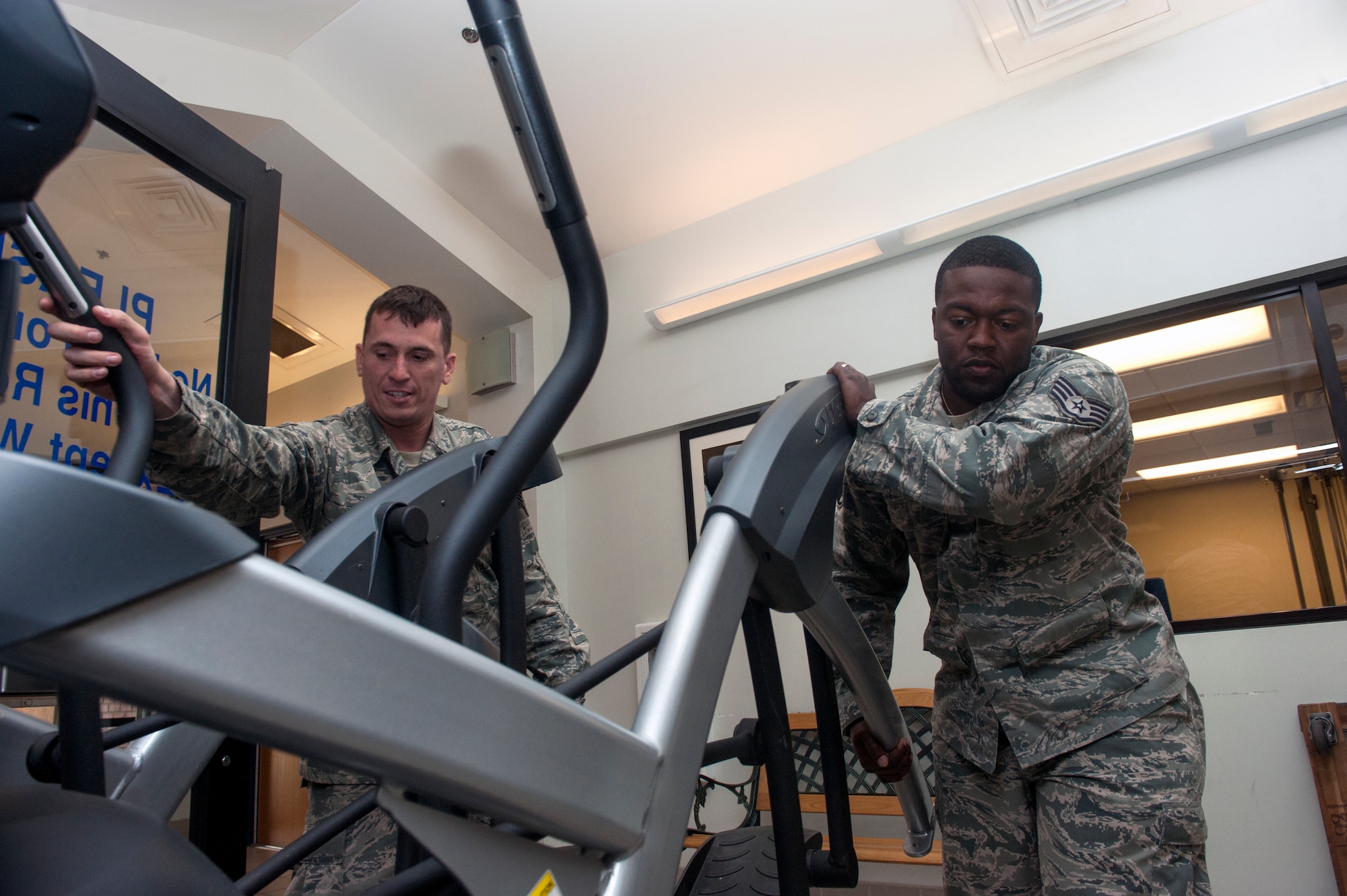 U.S. Air Force Staff Sgts. Jeffrey Stuart, left, and Michael Chapman, both 23d Force Support Squadron fitness center shift supervisors, rearrange cardio equipment Nov. 5, 2014, at Moody Air Force Base, Ga. The two were rearranging the equipment after a shipment of 24 new machines arrived the day prior. (U.S. Air Force photo by Senior Airman Jarrod Grammel/Released)
