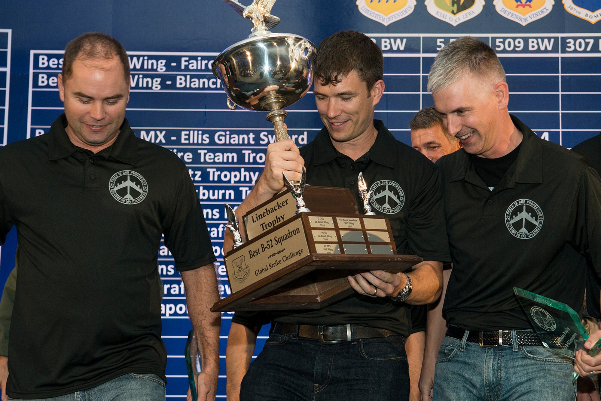 U.S. Air Force Maj. Warren Carroll carries the Linebacker Trophy after the 93rd Bomb Squadron's (BS) win during the Air Force Global Strike Challenge score posting, Nov. 5, 2014, Barksdale Air Force Base, La. The 93rd BS won the trophy for "Best B-52 Squadron" in the Air Force. (U.S. Air Force photo by Master Sgt. Greg Steele/Released)