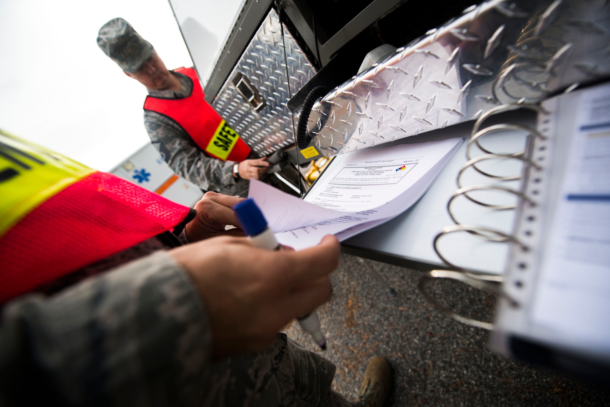 U.S. Air Force Tech. Sgt. Jeremy Miller, 23d Civil Engineer Squadron incident commander, reviews a material safety data sheet during  a fuel containment exercise Nov. 5, 2014, at Moody Air Force Base, Ga. Miller used the MSDS during a simulated fuel spill to identify the substance and its hazards. (U.S. Air Force photo by Airman 1st Class Dillian Bamman/Released)