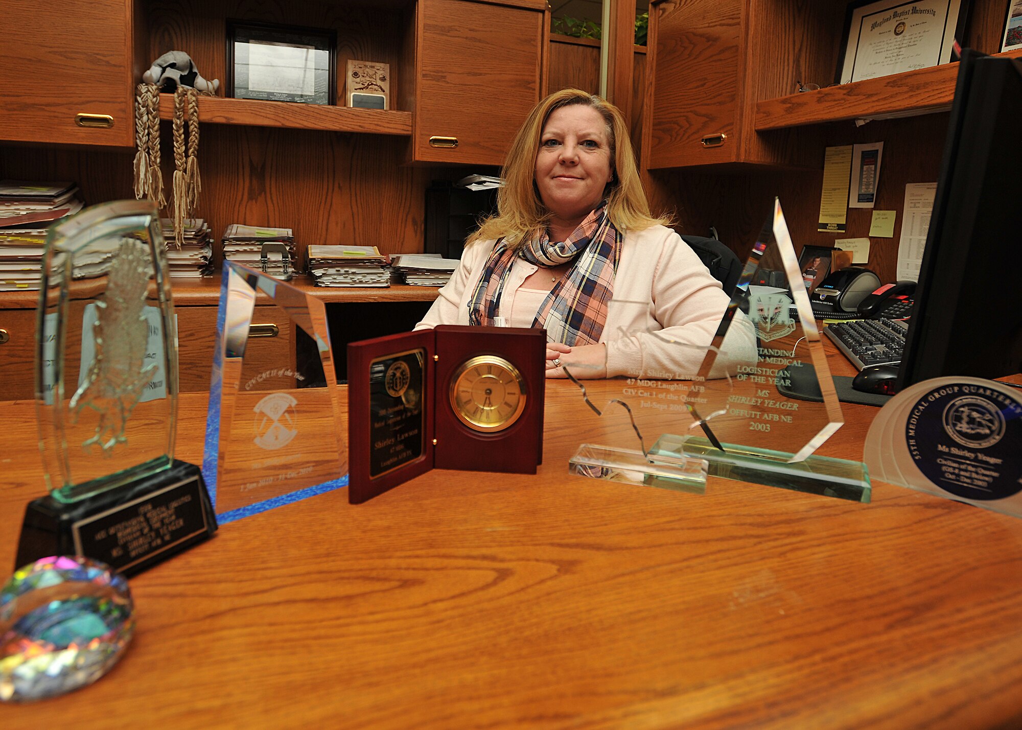 Shirley Lawson, 319th Contracting Flight contract specialist, poses with several awards she has won on six different military bases on Nov. 6, 2014. Lawson was named the Grand Forks AFB Warrior of the Week for the first week of November 2014. (U.S. Air Force photo/Senior Airman Xavier Navarro)