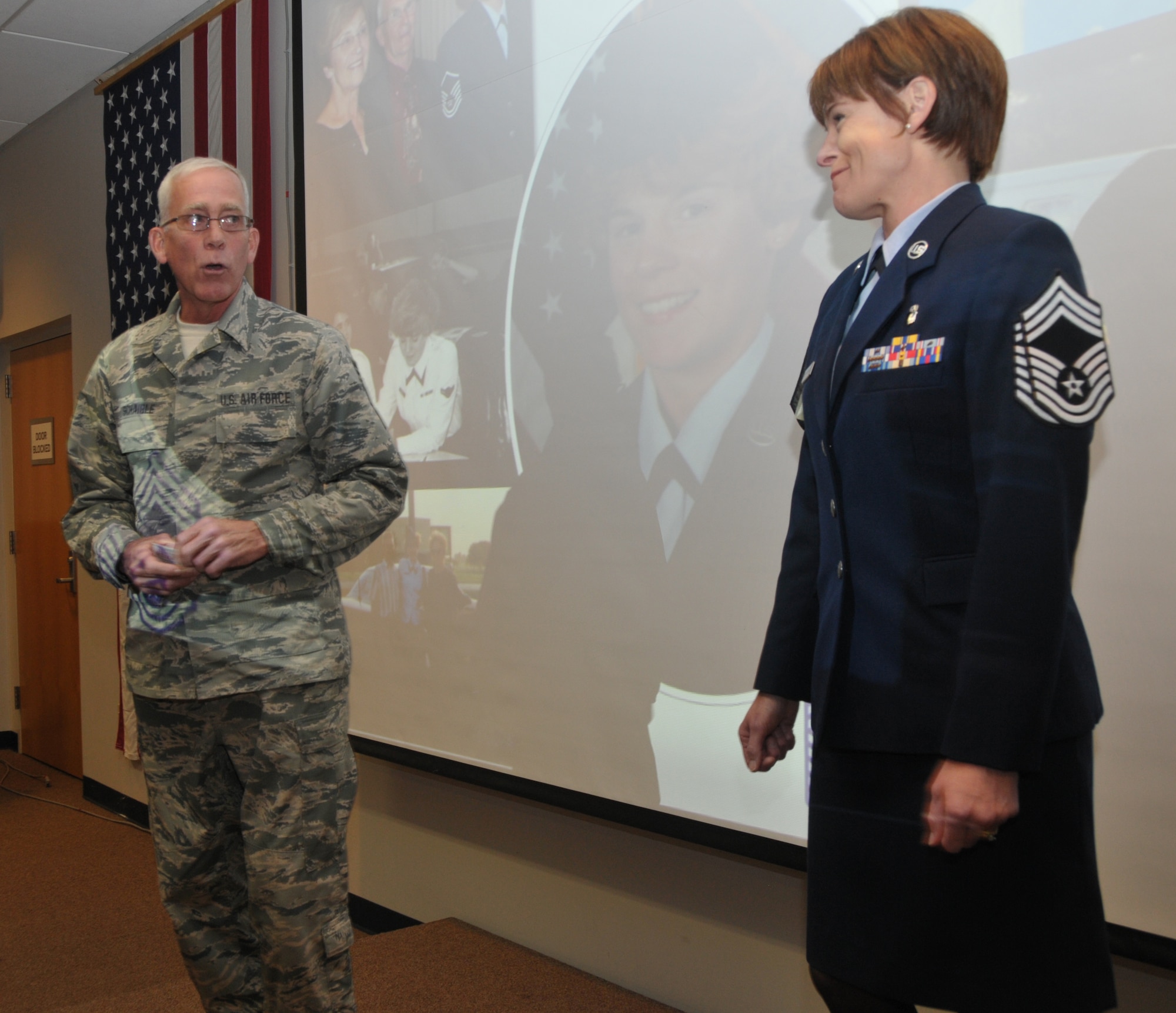 Chief Master Sgt. Mark Schaible welcomes newly promoted Chief Master Sgt. Jacqueline Sweet-McNeill to the chief rank with a coin during a ceremony on Stratton Air National Guard Base, New York, on Nov. 2, 2014. Sweet-McNeill is the 109th Medical Group superintendent. (U.S. Air National Guard photo by Tech. Sgt. Catharine Schmidt/Released)