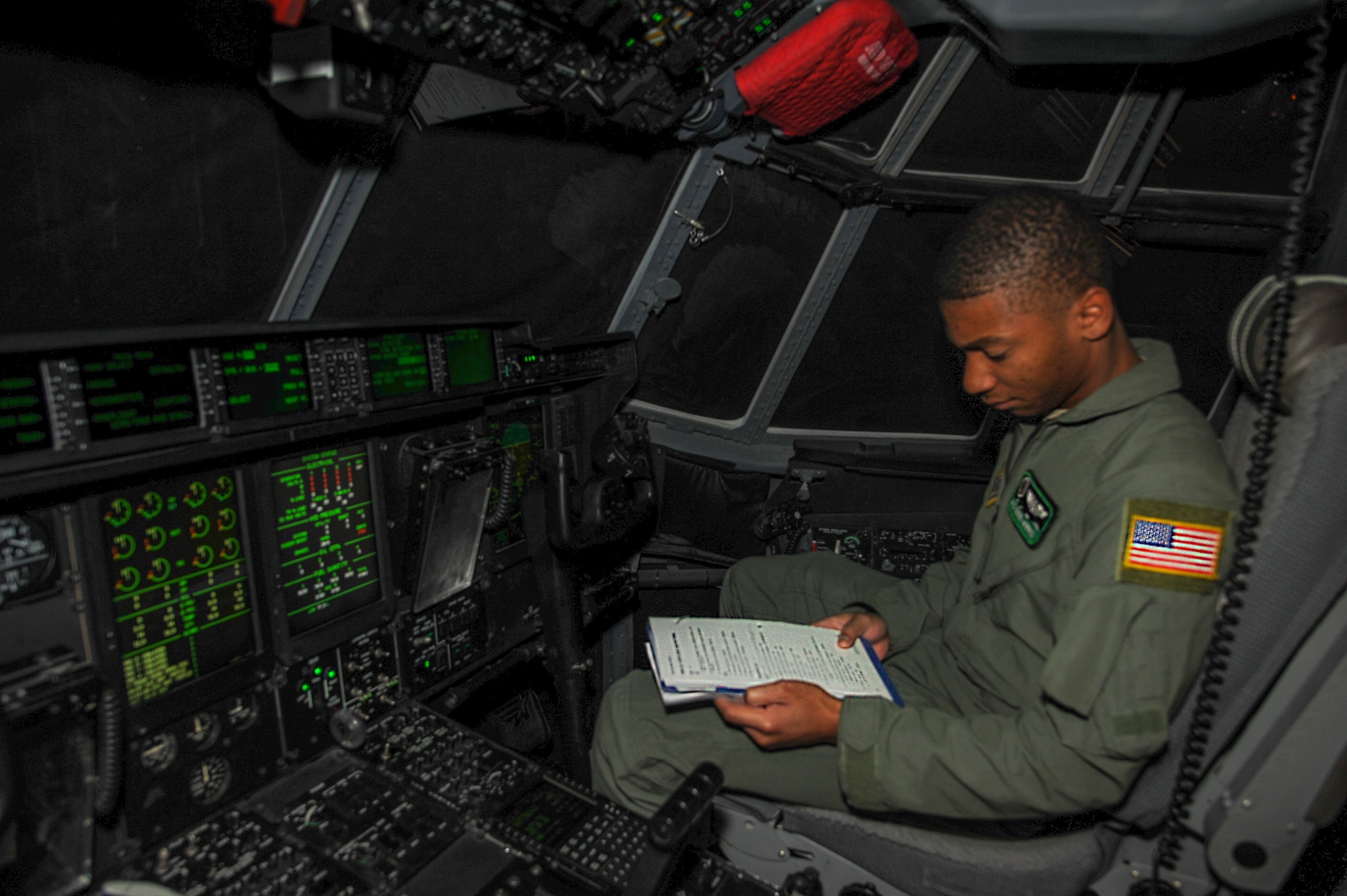 Airman 1st Class Quinn Harris, a 52nd Airlift Squadron loadmaster, reviews a pre-flight checklist in a C-130J cockpit trainer Oct. 29, 2014, at Little Rock Air Force Base, Ark. Harris is undergoing qualification training before his next assignment to the 37th Airlift Squadron at Ramstein Air Base, Germany. (U.S. Air Force photo by Airman 1st Class Harry Brexel)